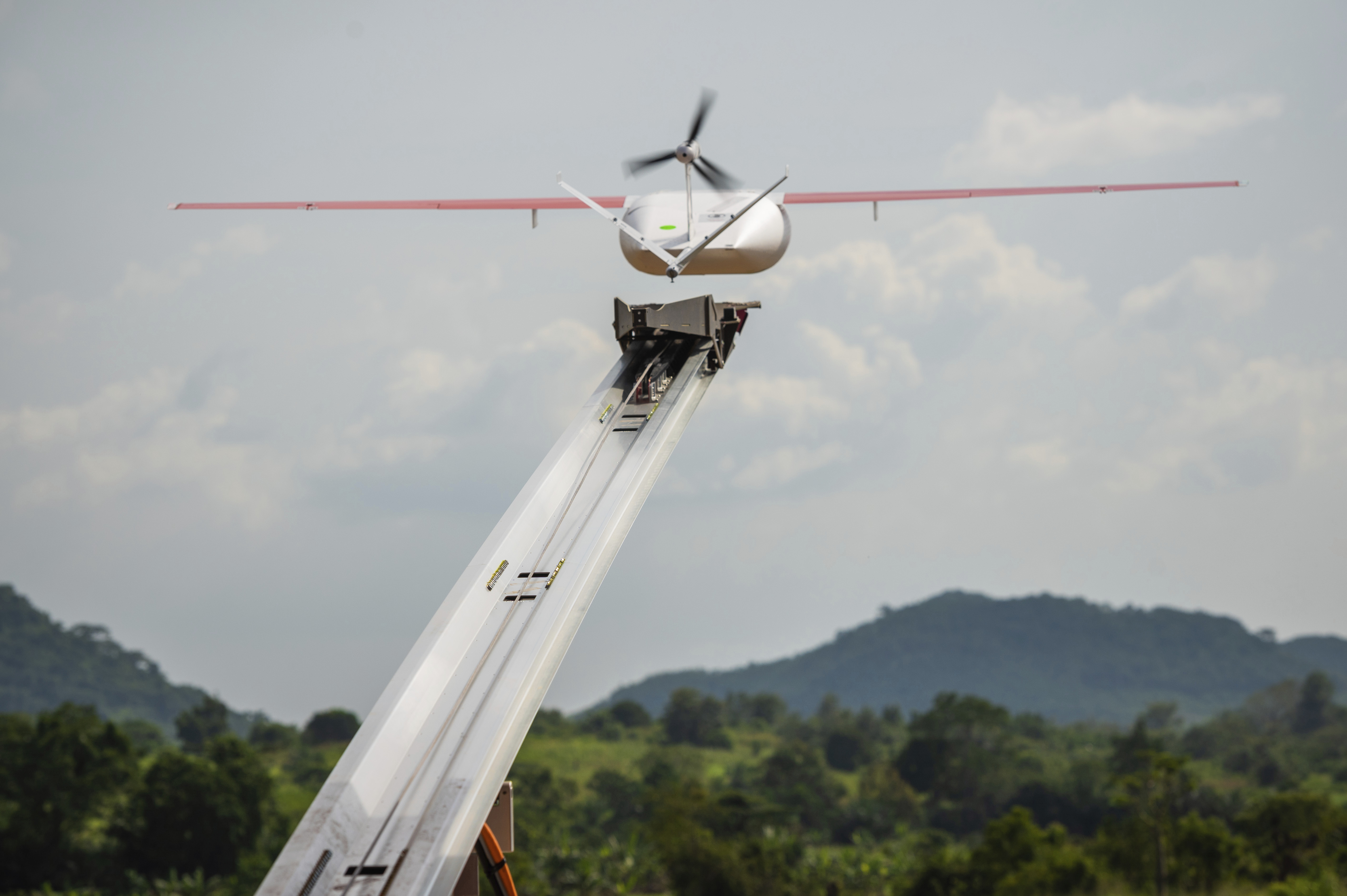 A drone flies to make a delivery at a Zipline hub in Vobsi