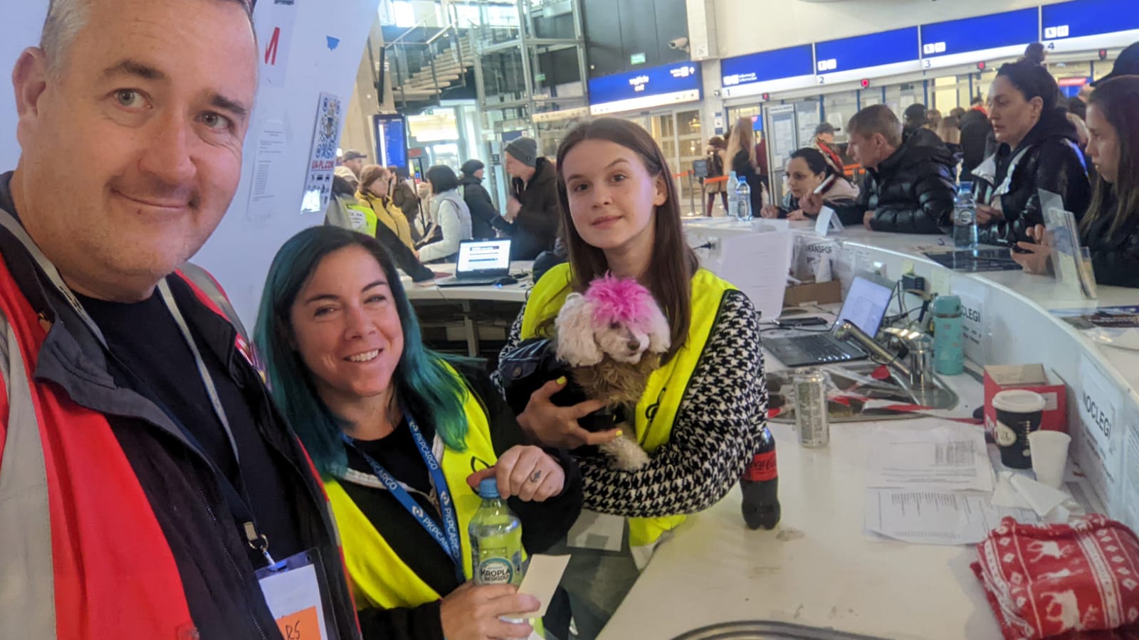 Helpers at Warsaw Central train station pose for a photo with Juno the dog