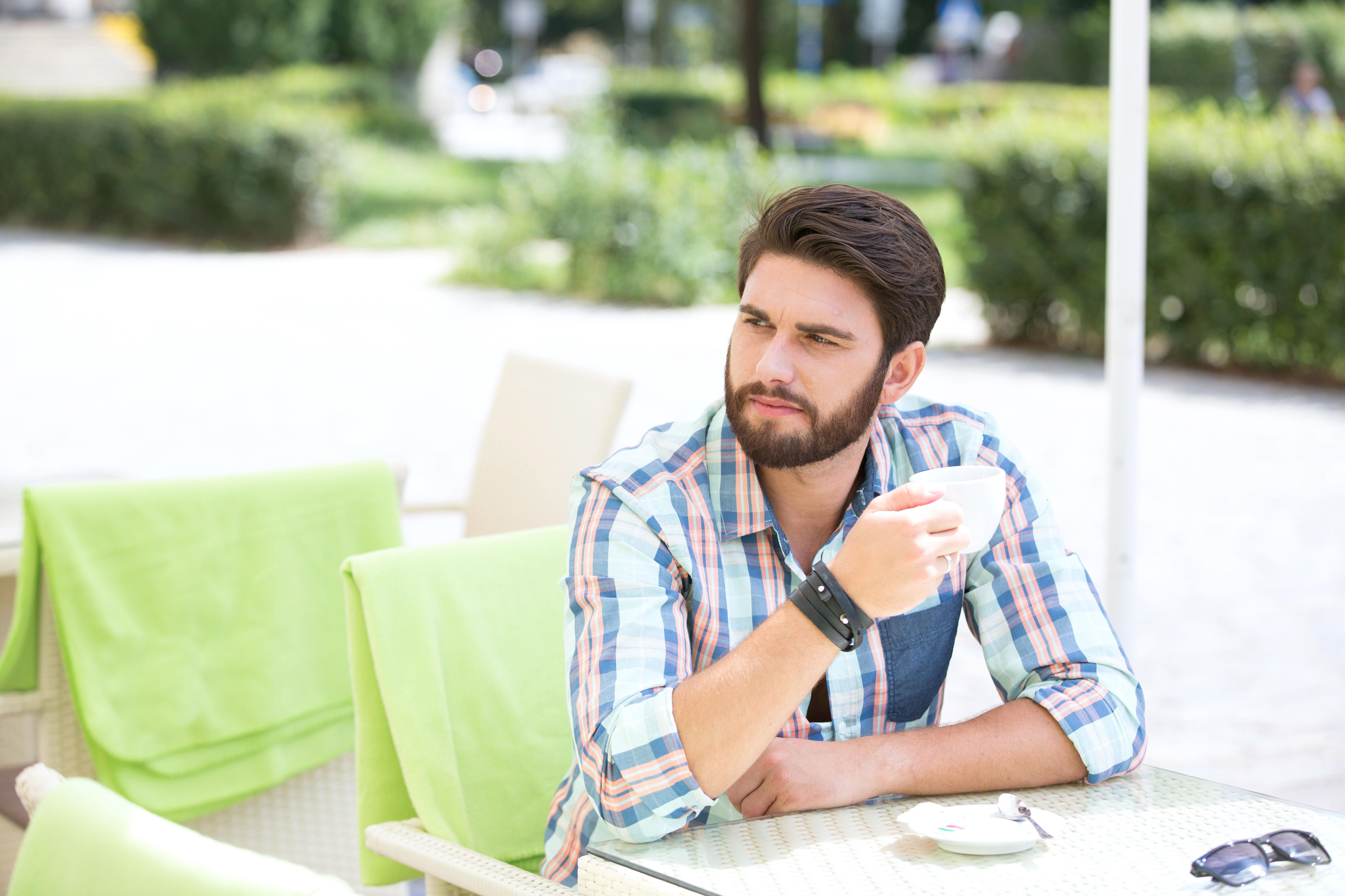 Thoughtful man having a coffee in outdoor cafe