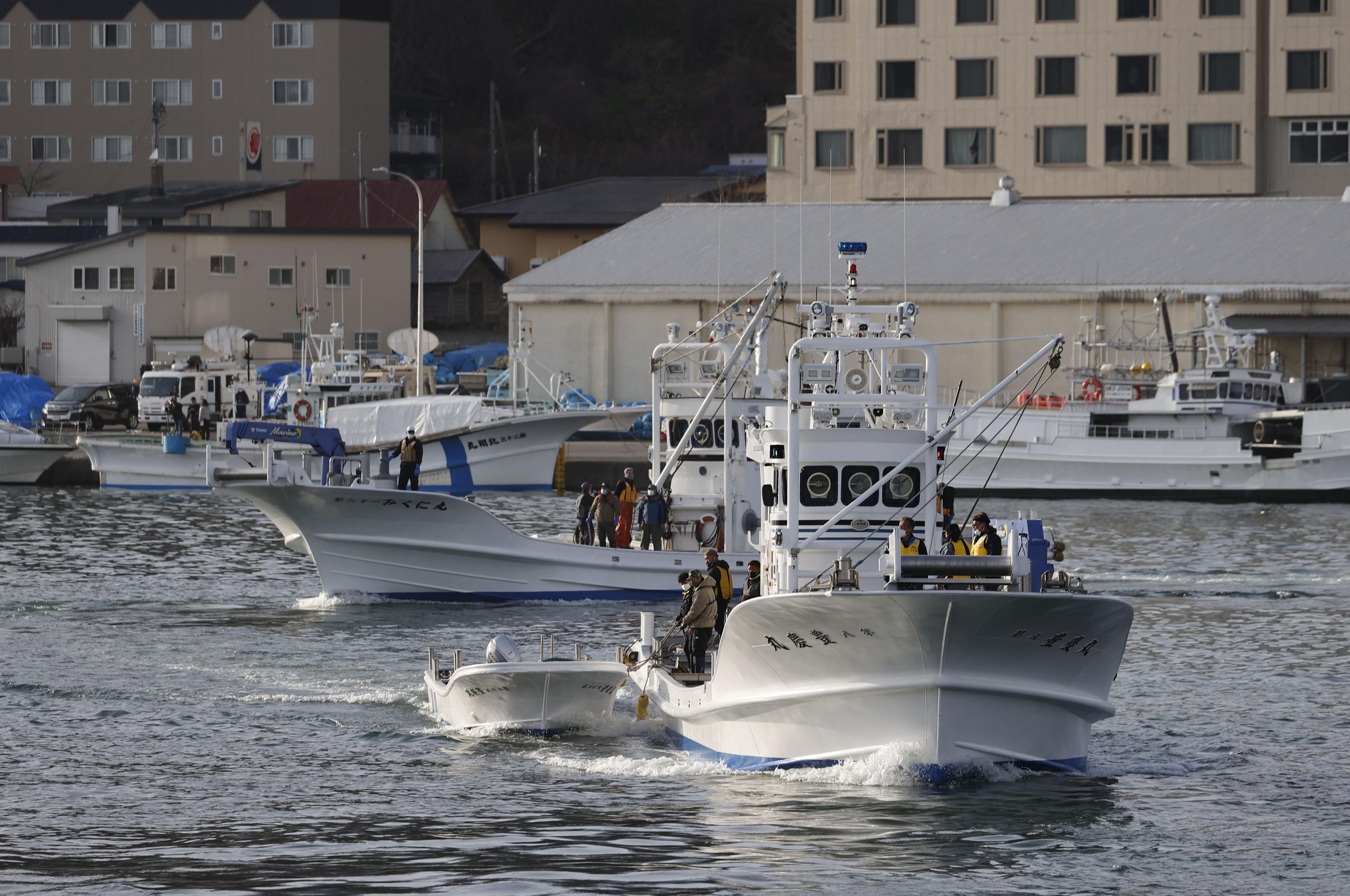 Fishing boats leave a port to search for a missing tour boat in Shari, in the northern island of Hokkaido 