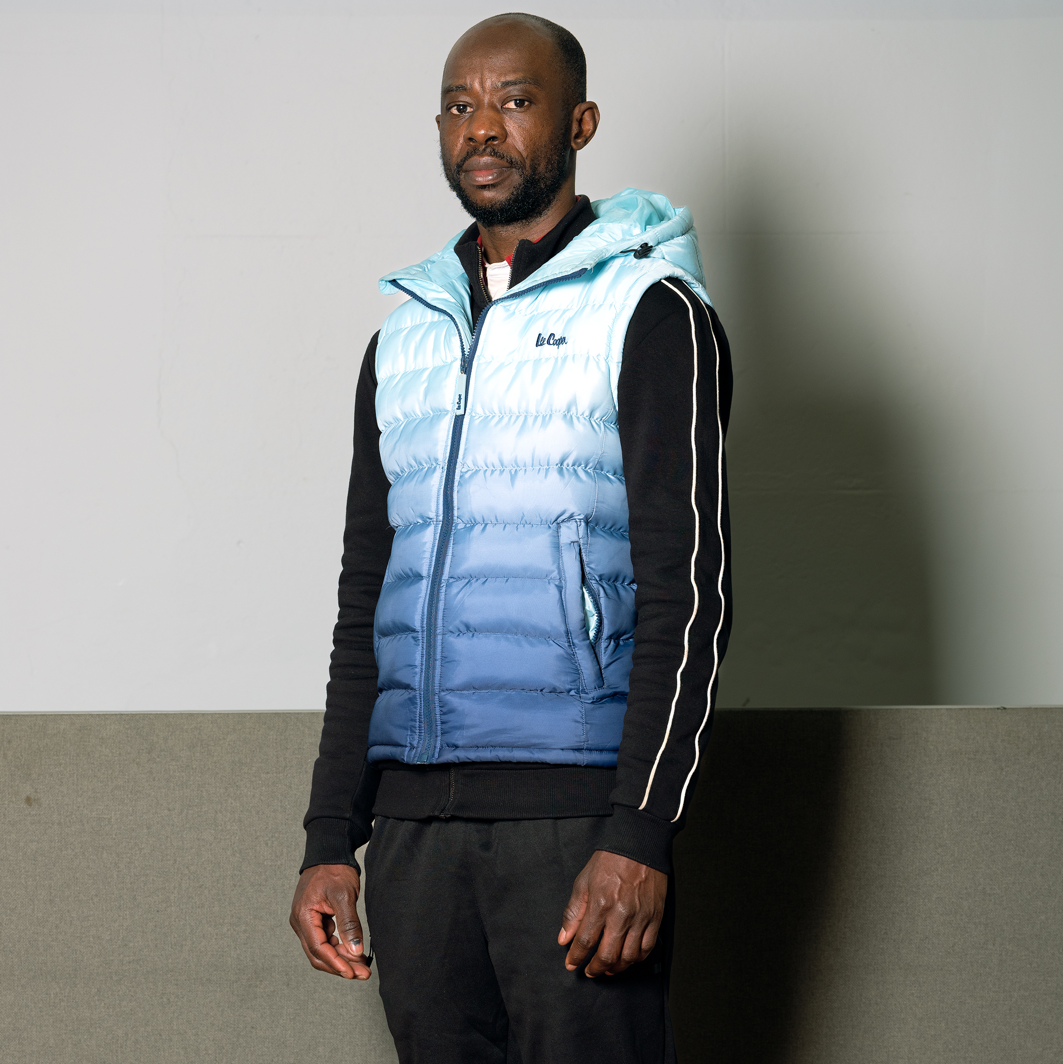 Siki wearing a blue and white gillet and looking at the camera