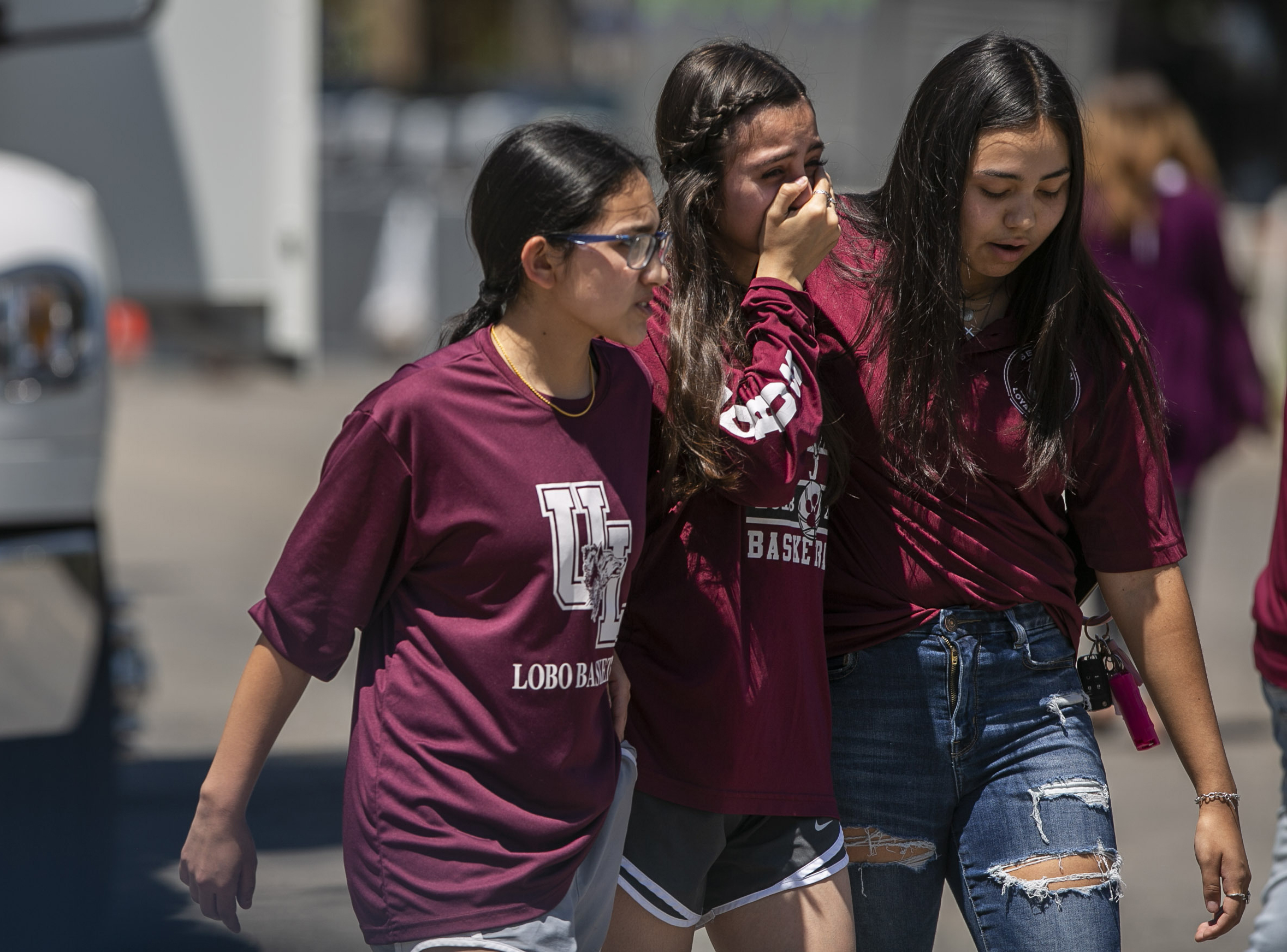 Overcome with emotion, young people comfort each other after leaving a memorial created outside Robb Elementary School in Uvalde, Texas, on Thursday