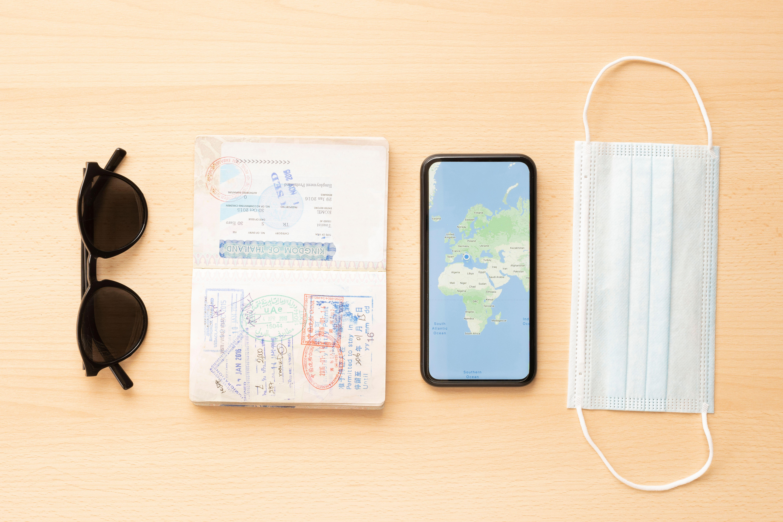 face mask, a passport, sunglasses and a smartphone