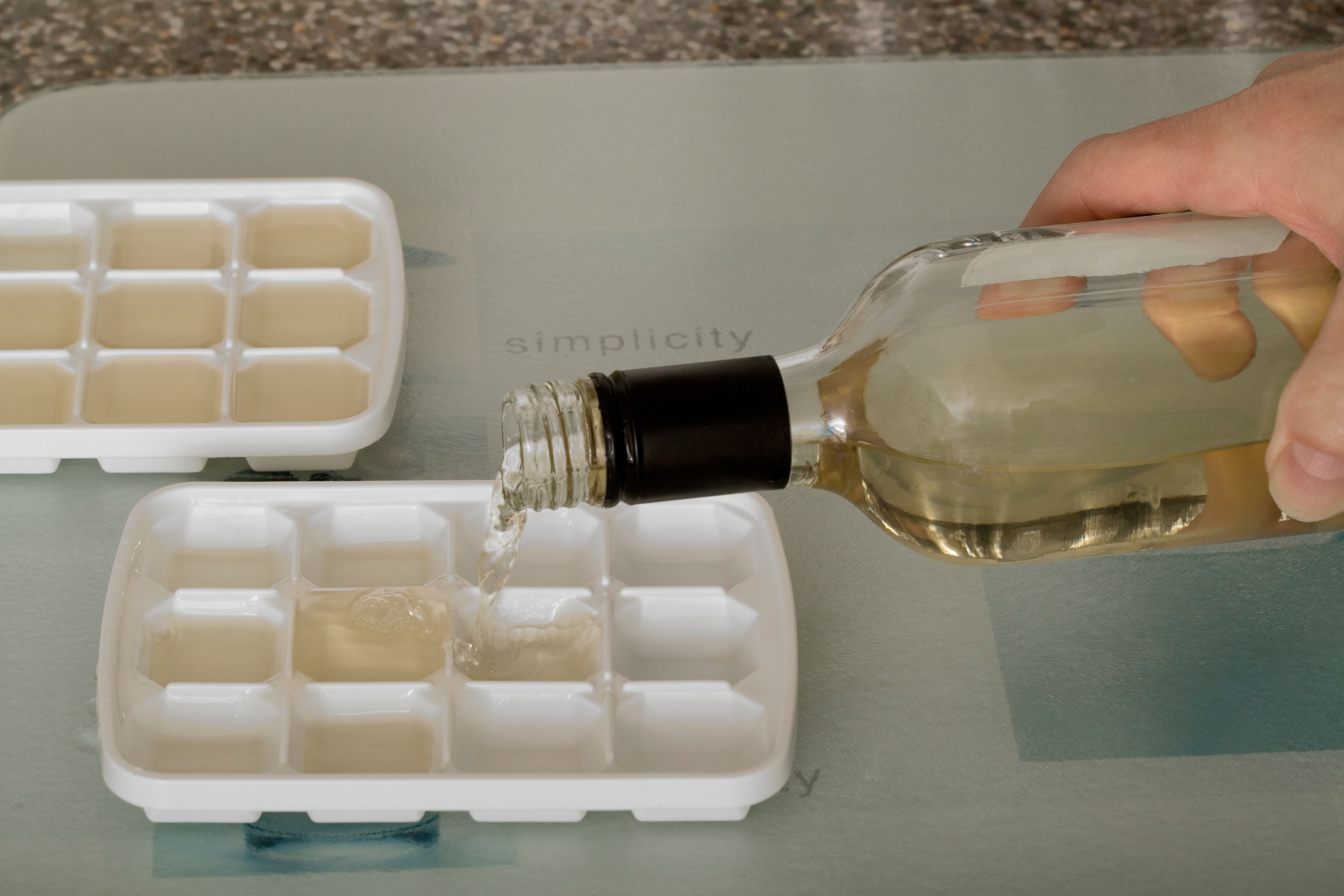 Left over wine being poured into ice cube trays