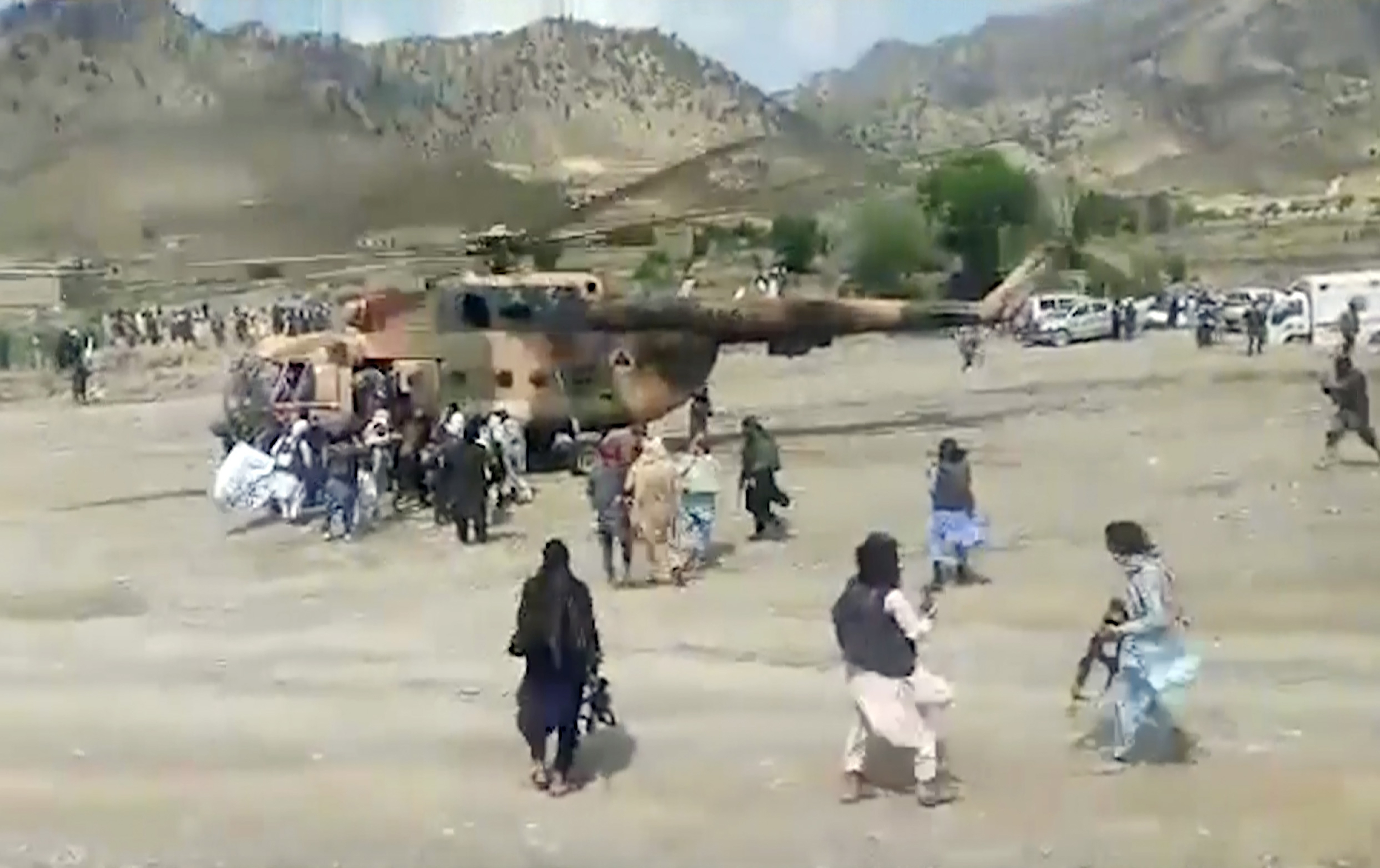 Taliban fighters secure a government helicopter to evacuate injured people in Gayan district, Paktika province, Afghanistan