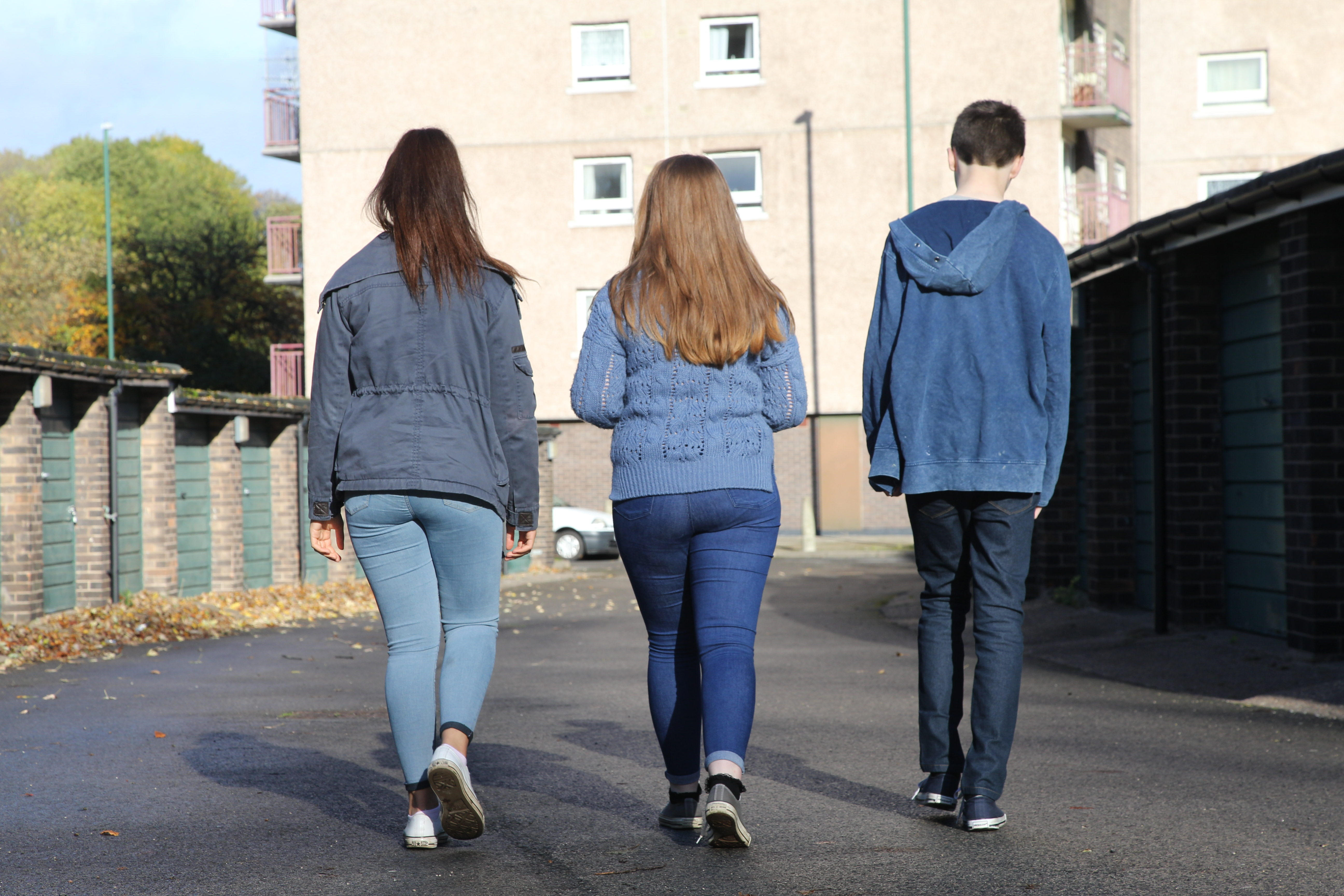 Back view of teenagers walking to flats