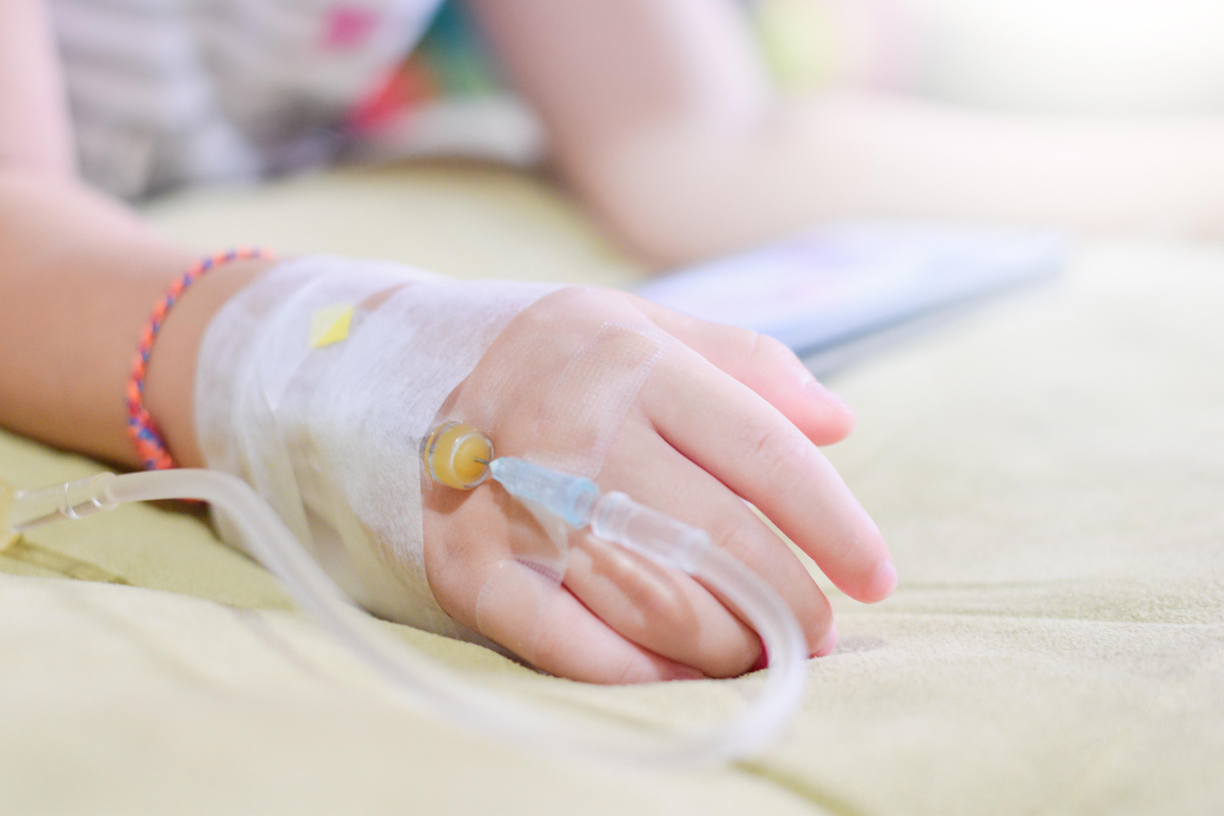 IV solution in a child's patients hand,Close up Children patient's hand receiving iv saline solution in hospital