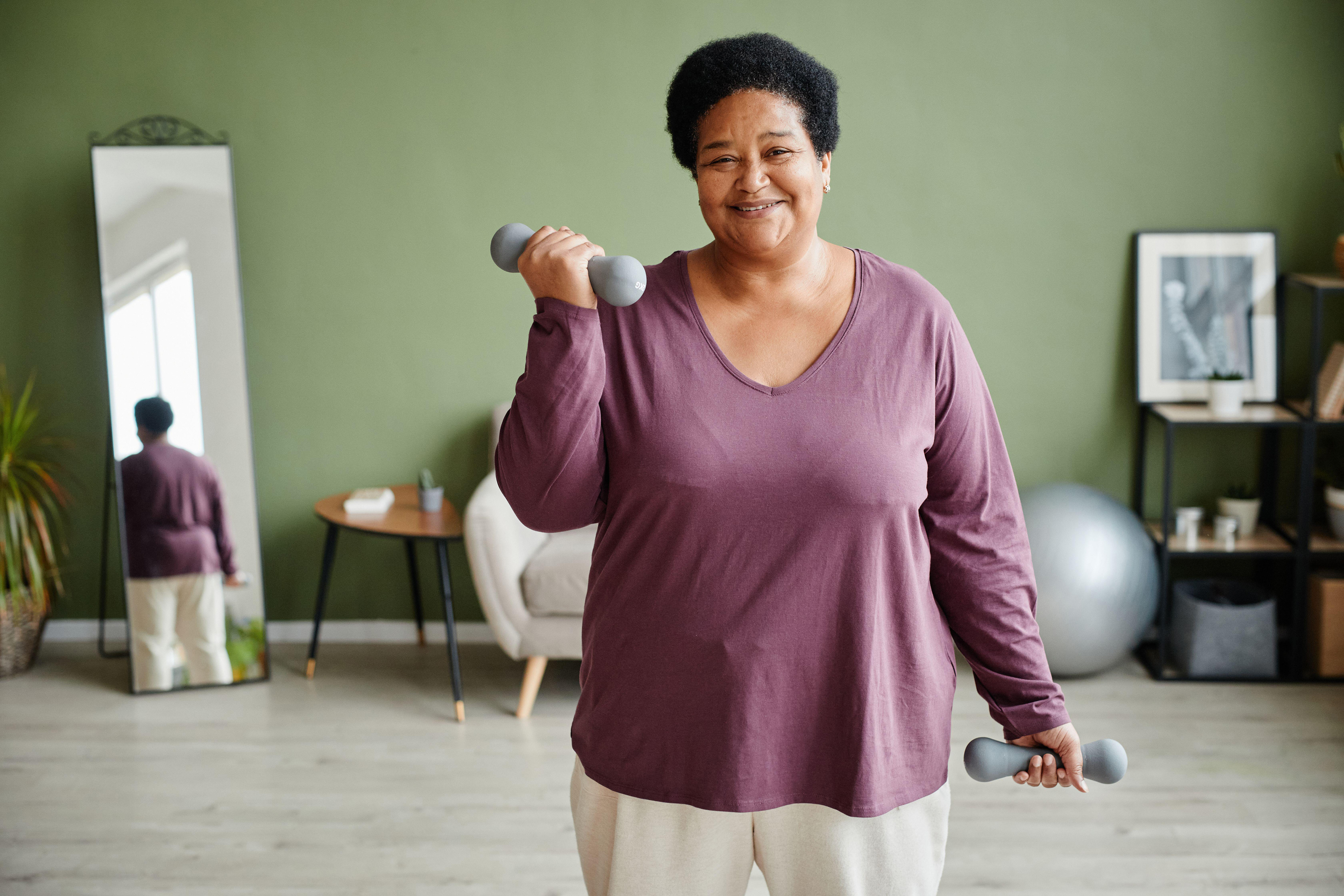 woman holding dumbbells and working out at home