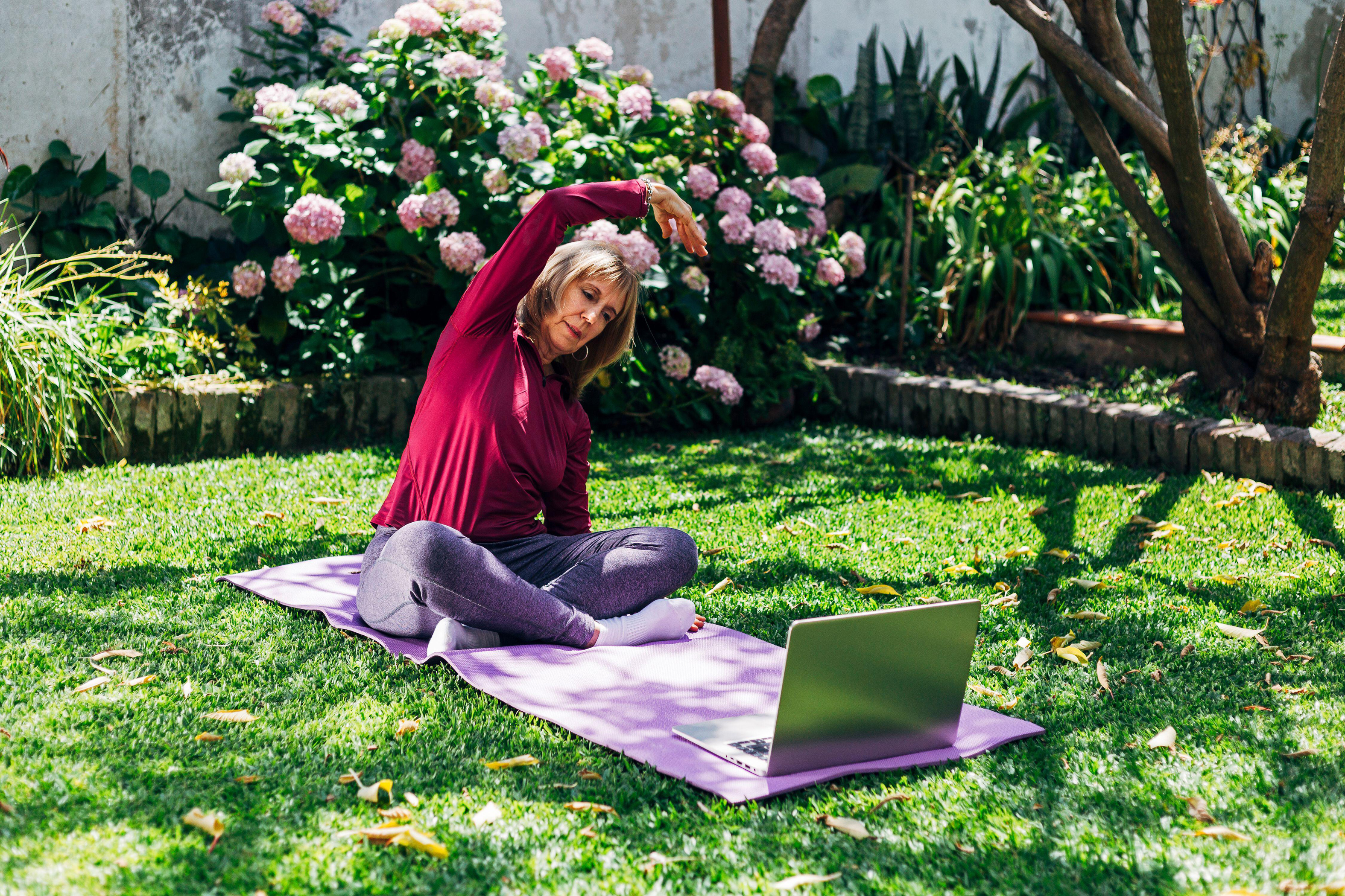 A woman stretching in the garden (Alamy/PA)