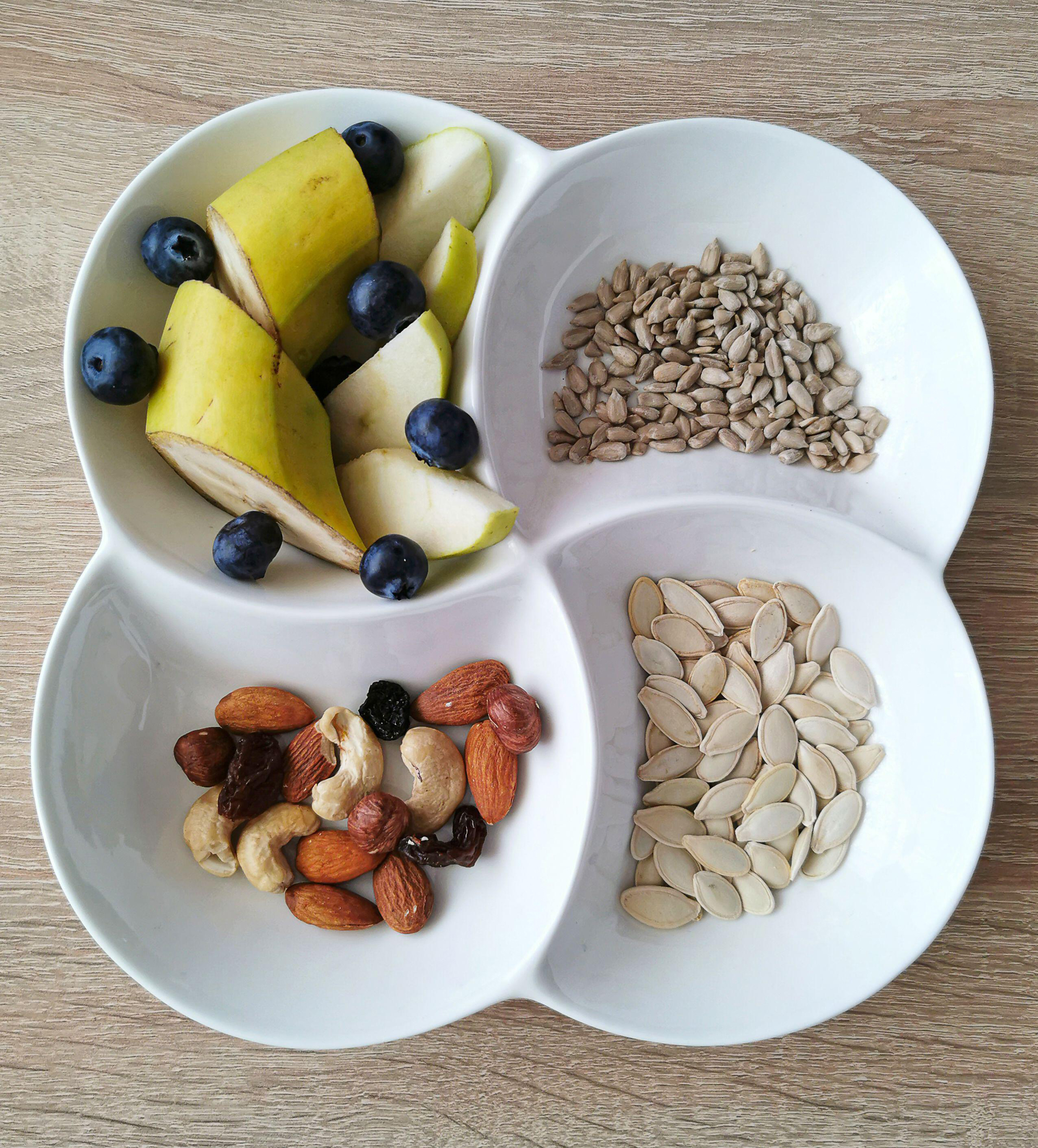 Banana pieces, nuts, sunflower and pumpkin seeds in a bowl