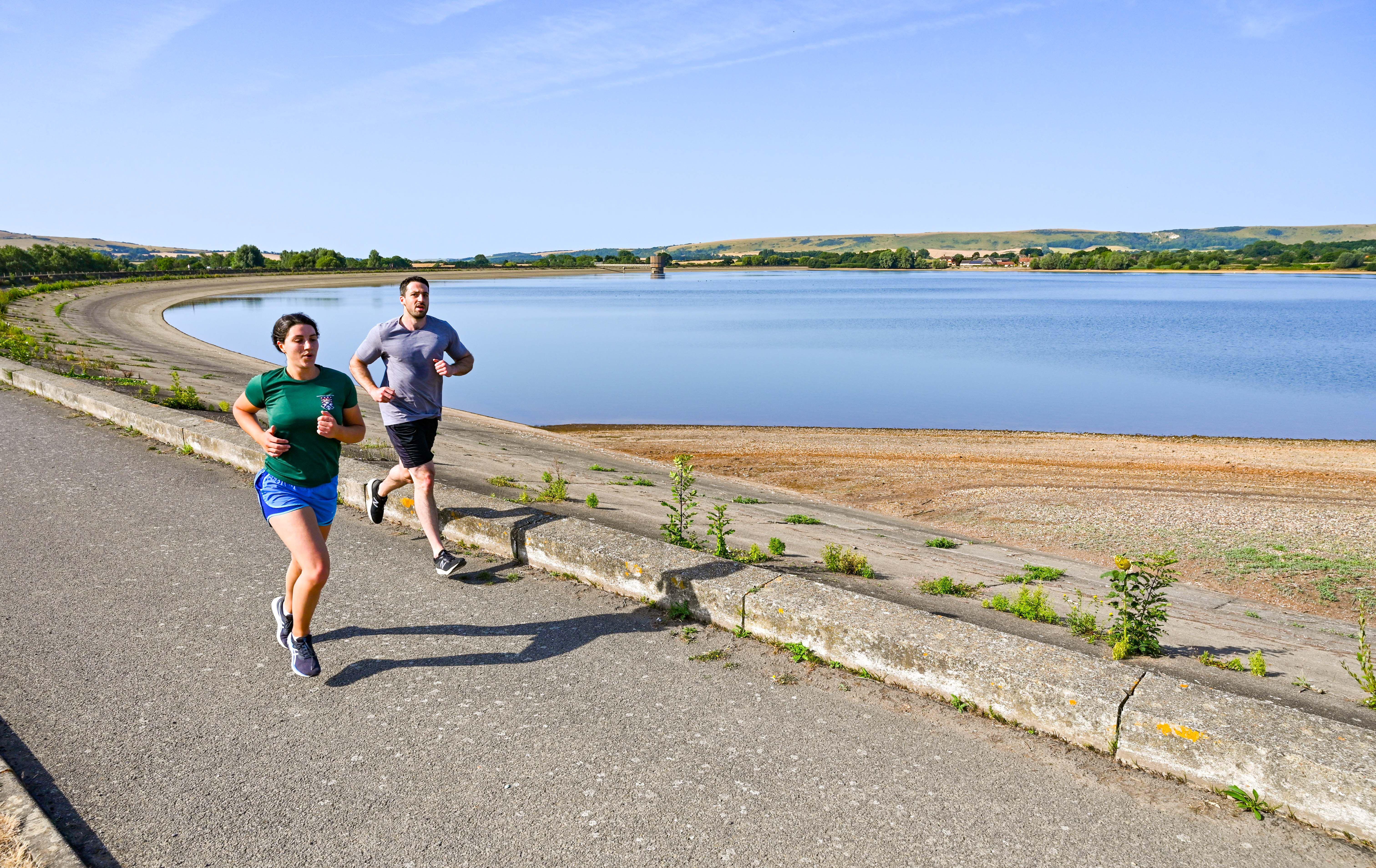 Early morning runners at Arlington Reservoir near Lewes in East Sussex in July