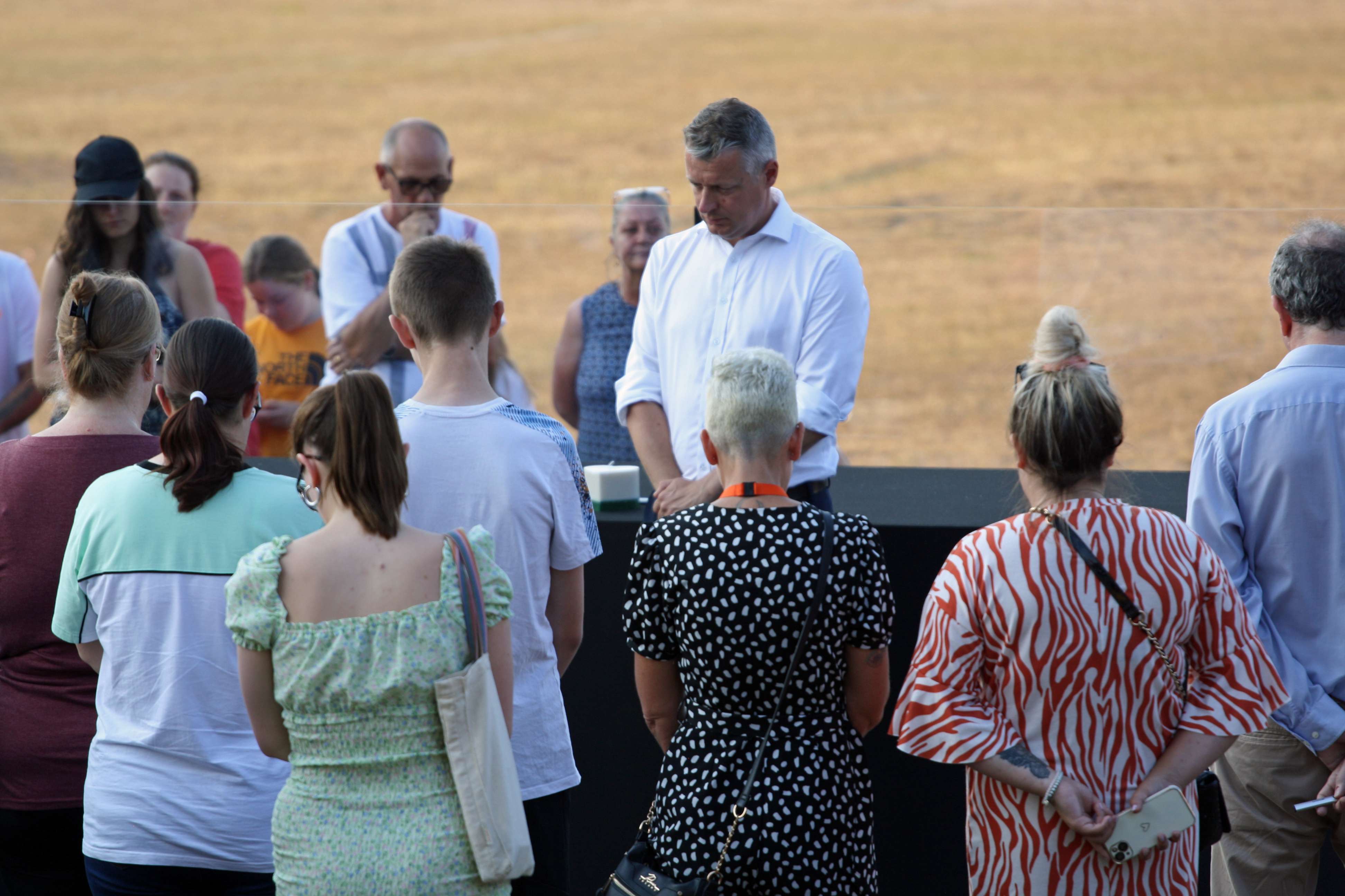 Local MP Luke Pollard and members of the public hold a minute's silence during a vigil at North Down Crescent Park in Keyham (Rod Minchin/PA)