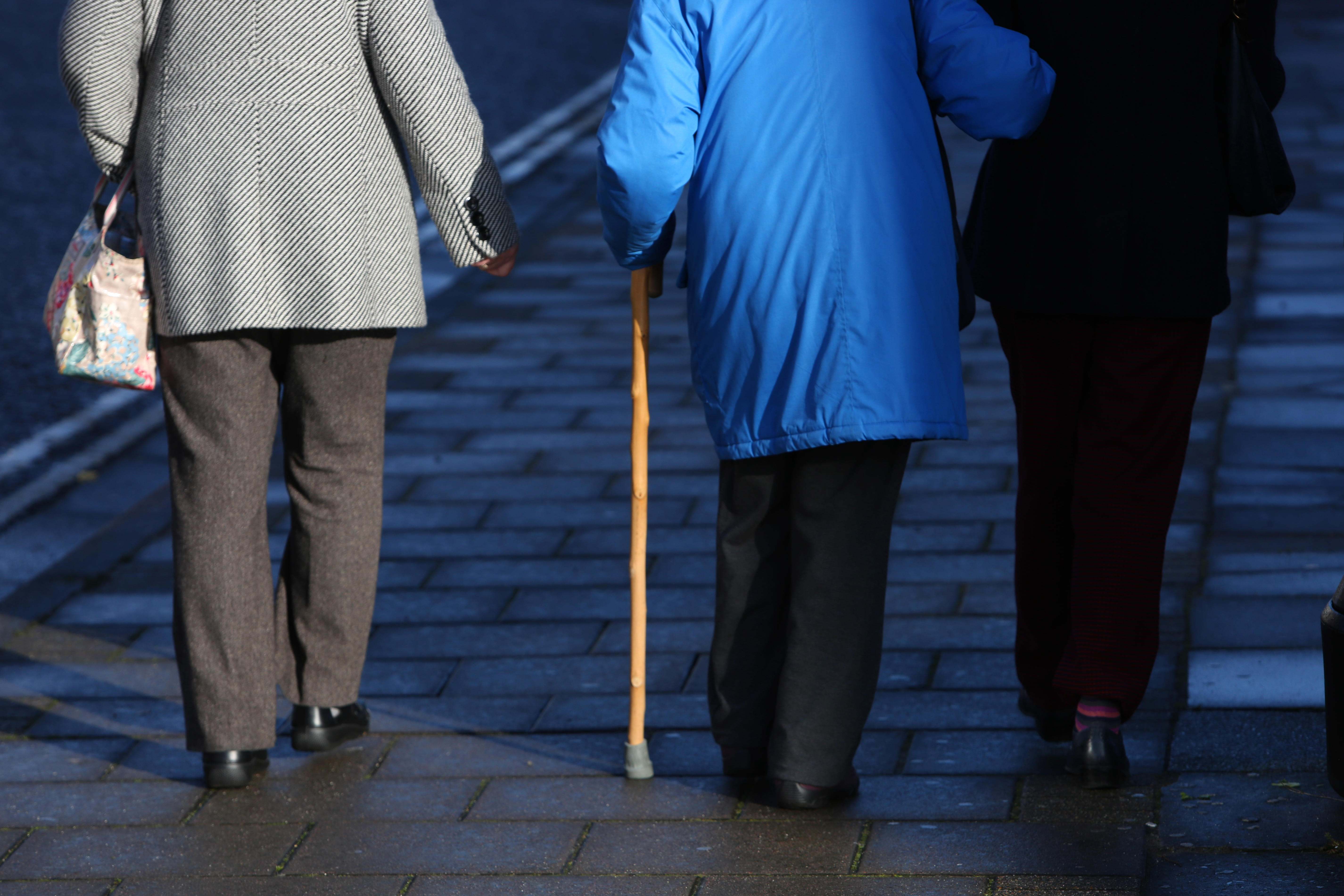 Three older women pictured walking along the street in Sussex, UK