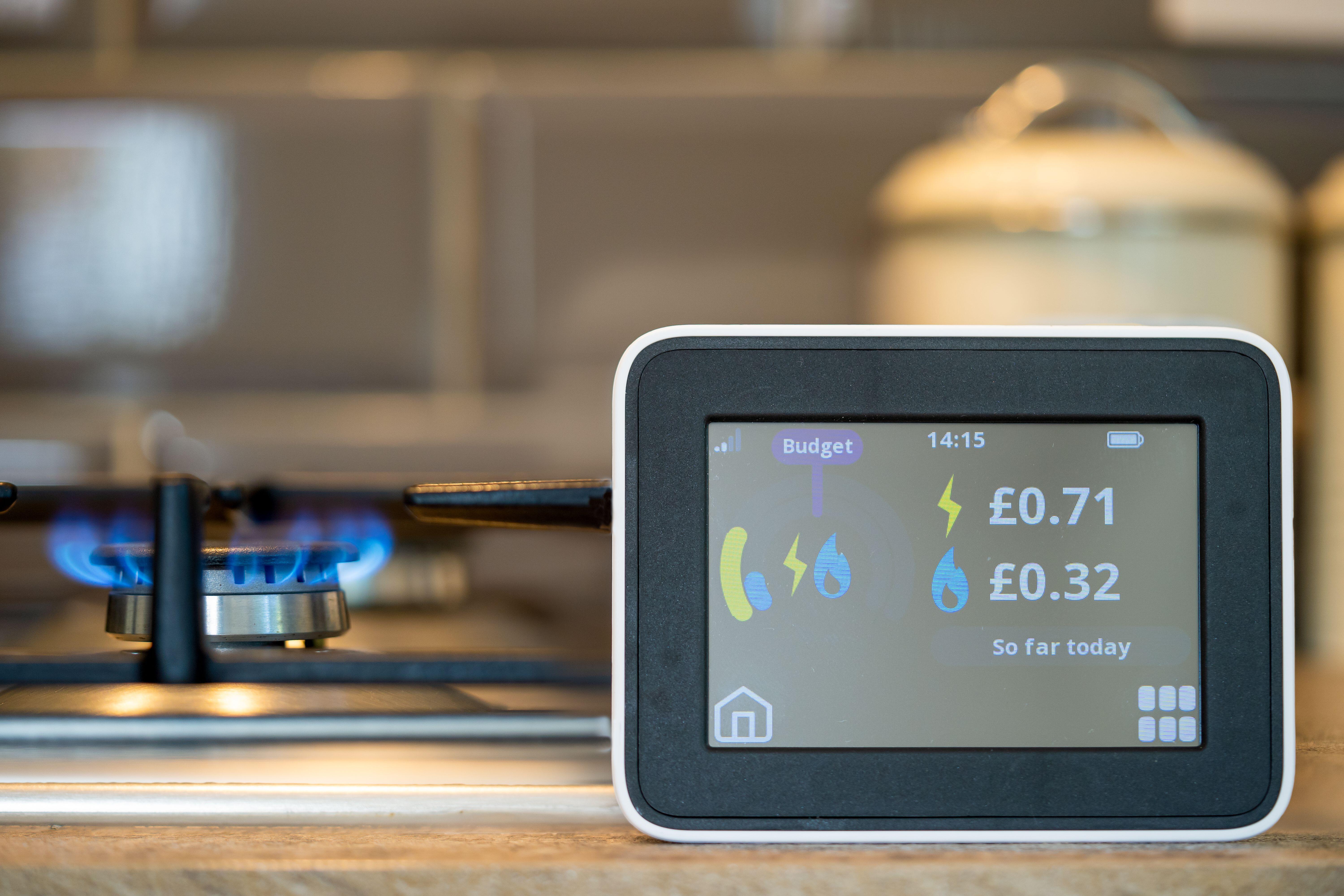 A smart meter against a background of a gas flame on a cooker