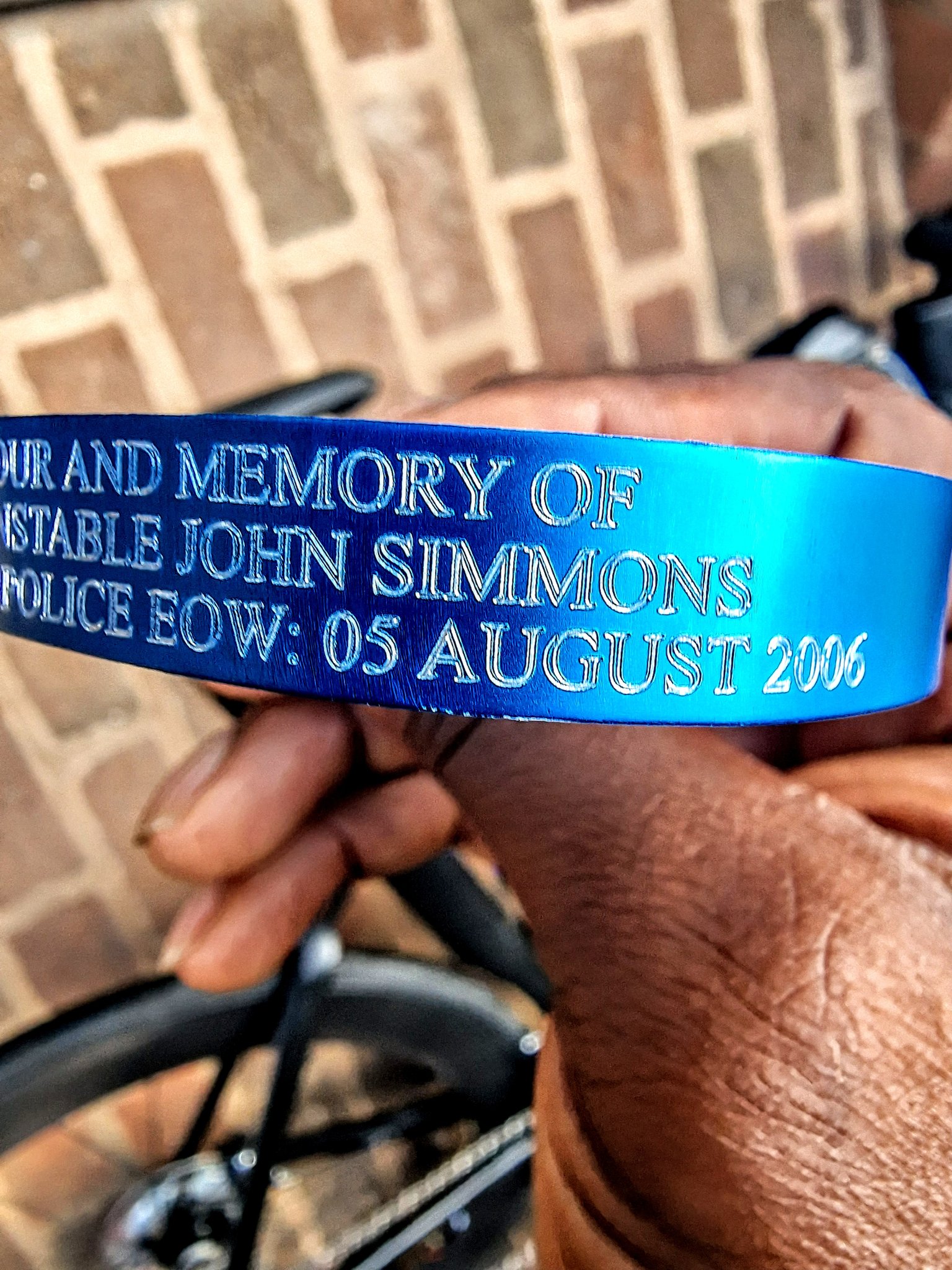 Man holding a blue band with writing engraved on it