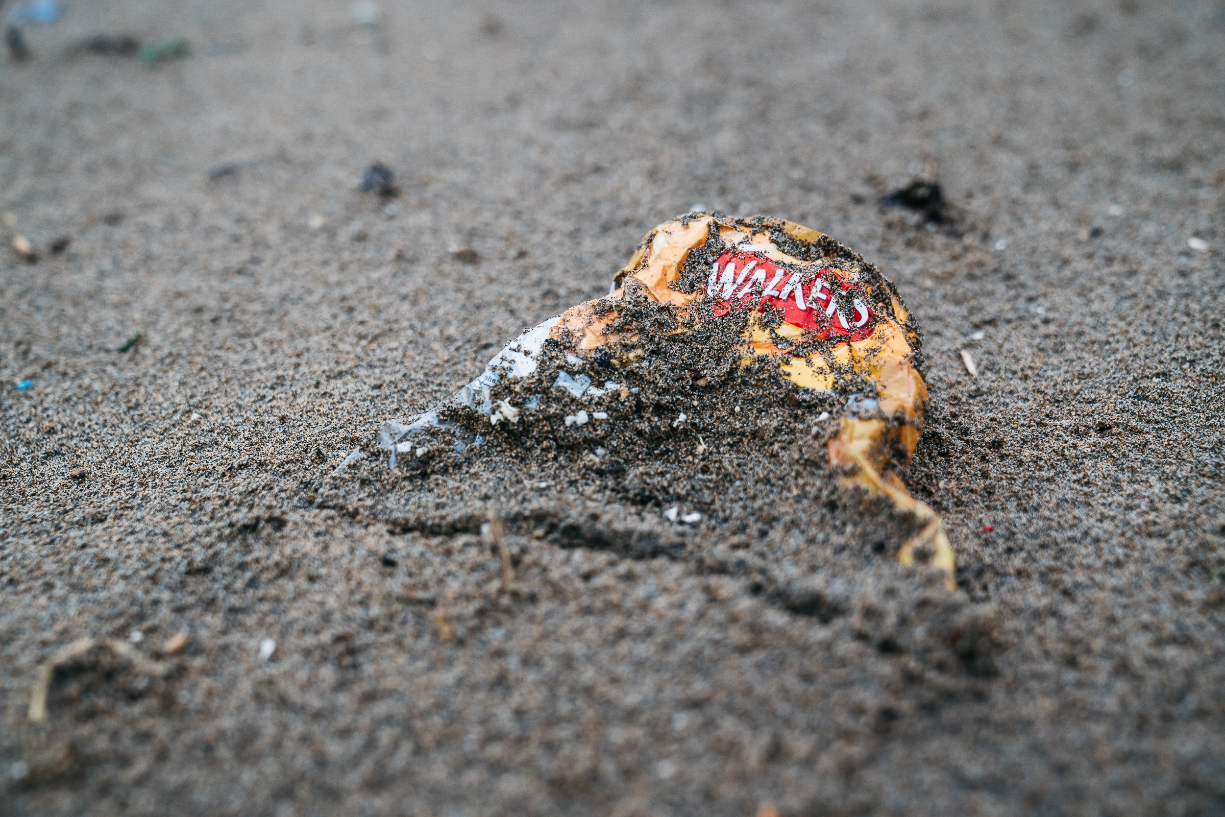 A Walkers Crisp packet in the sand (Ian Lean/Surfers Against Sewage/PA)