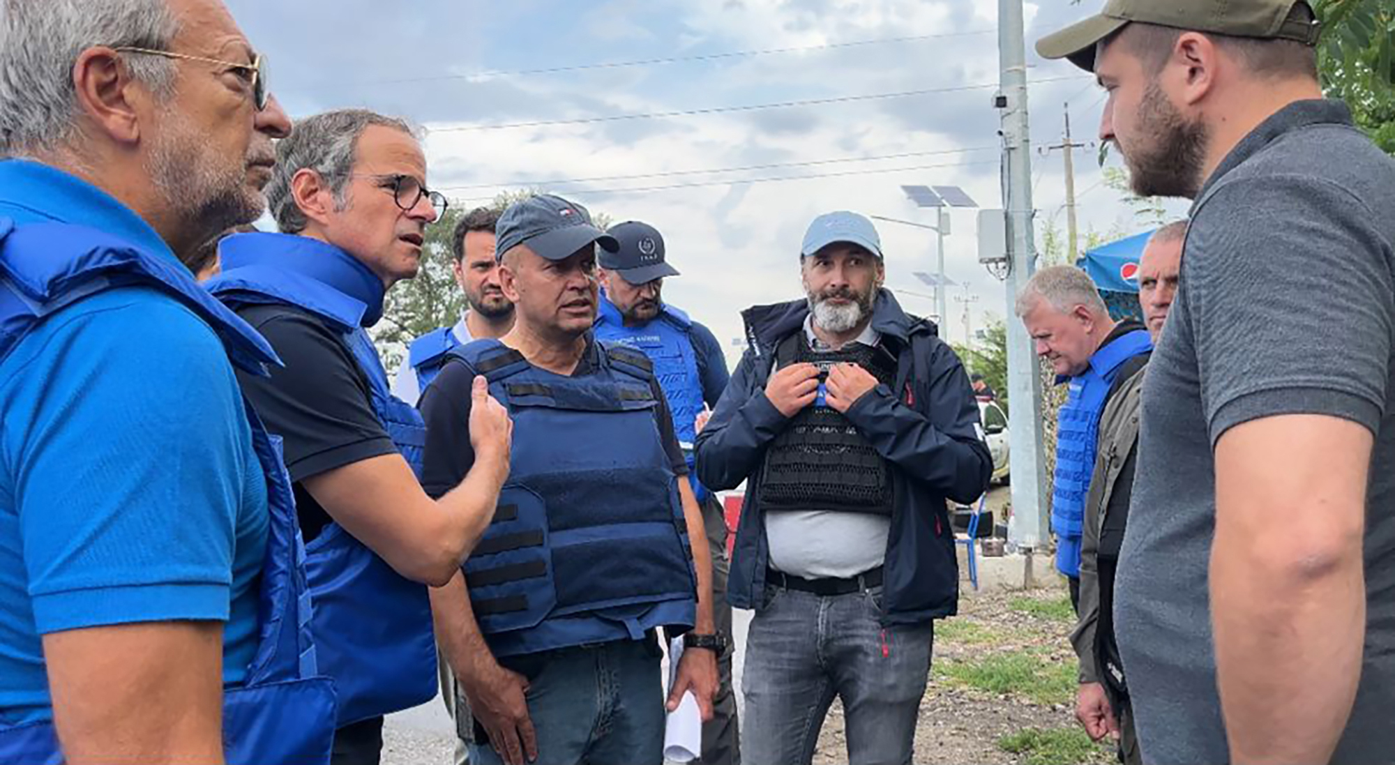 Rafael Grossi, second from left, speaks to unidentified authorities as the UN agency mission heads to the power plant 