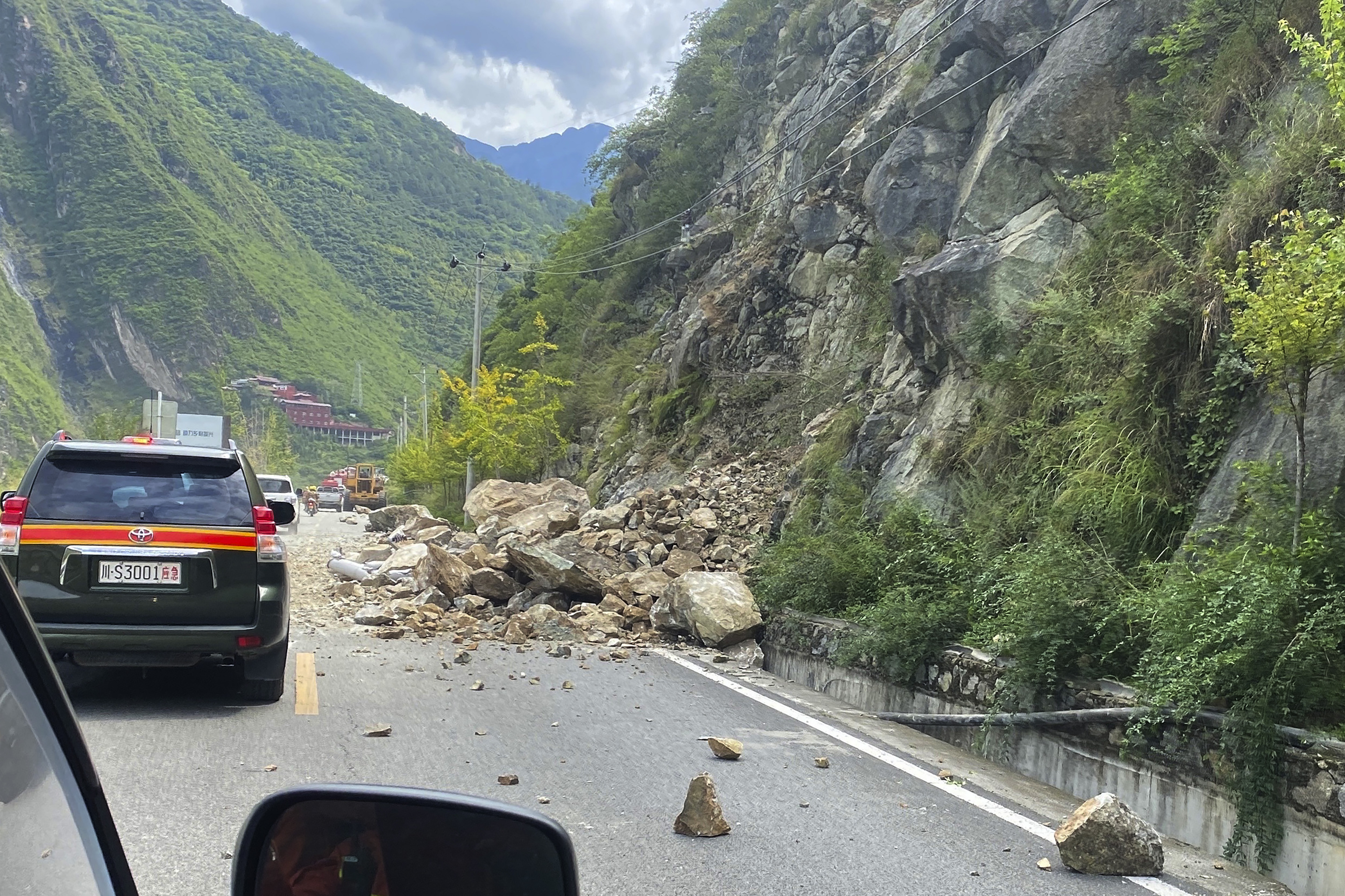 Fallen rocks are seen on the road heading to Luding County