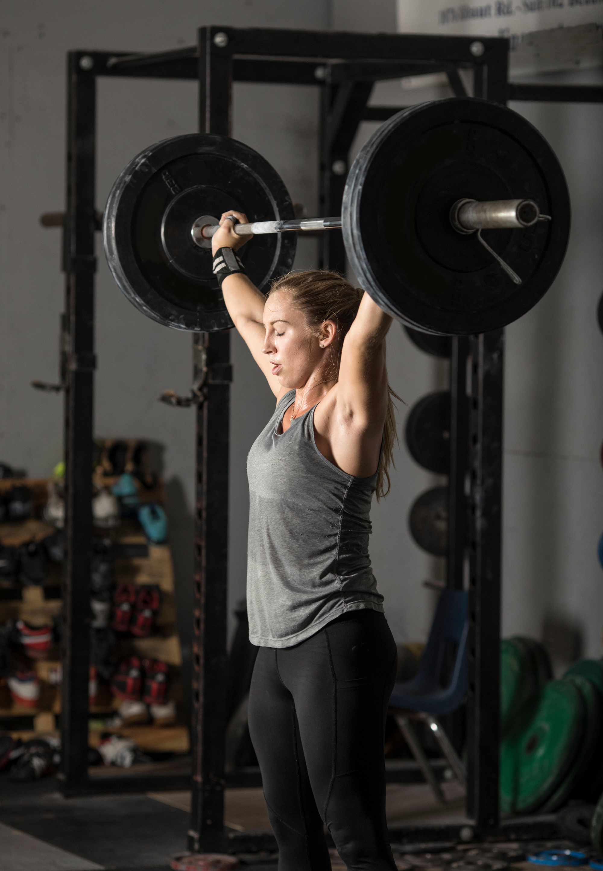 woman lifting heavy weights over her head.