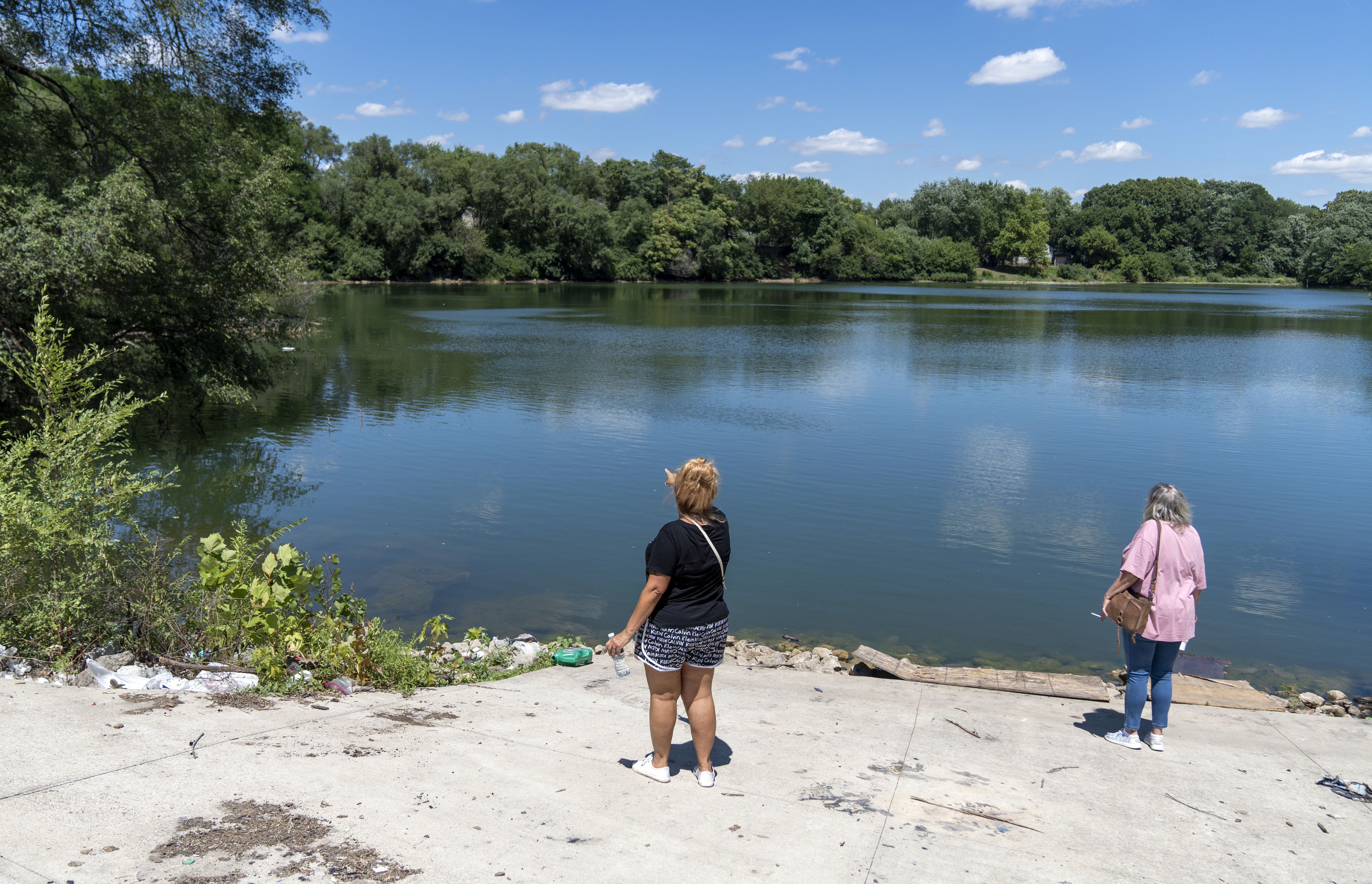 Searchers look at a large pond during a hunt for Kyle Moorman, who went missing with his three children