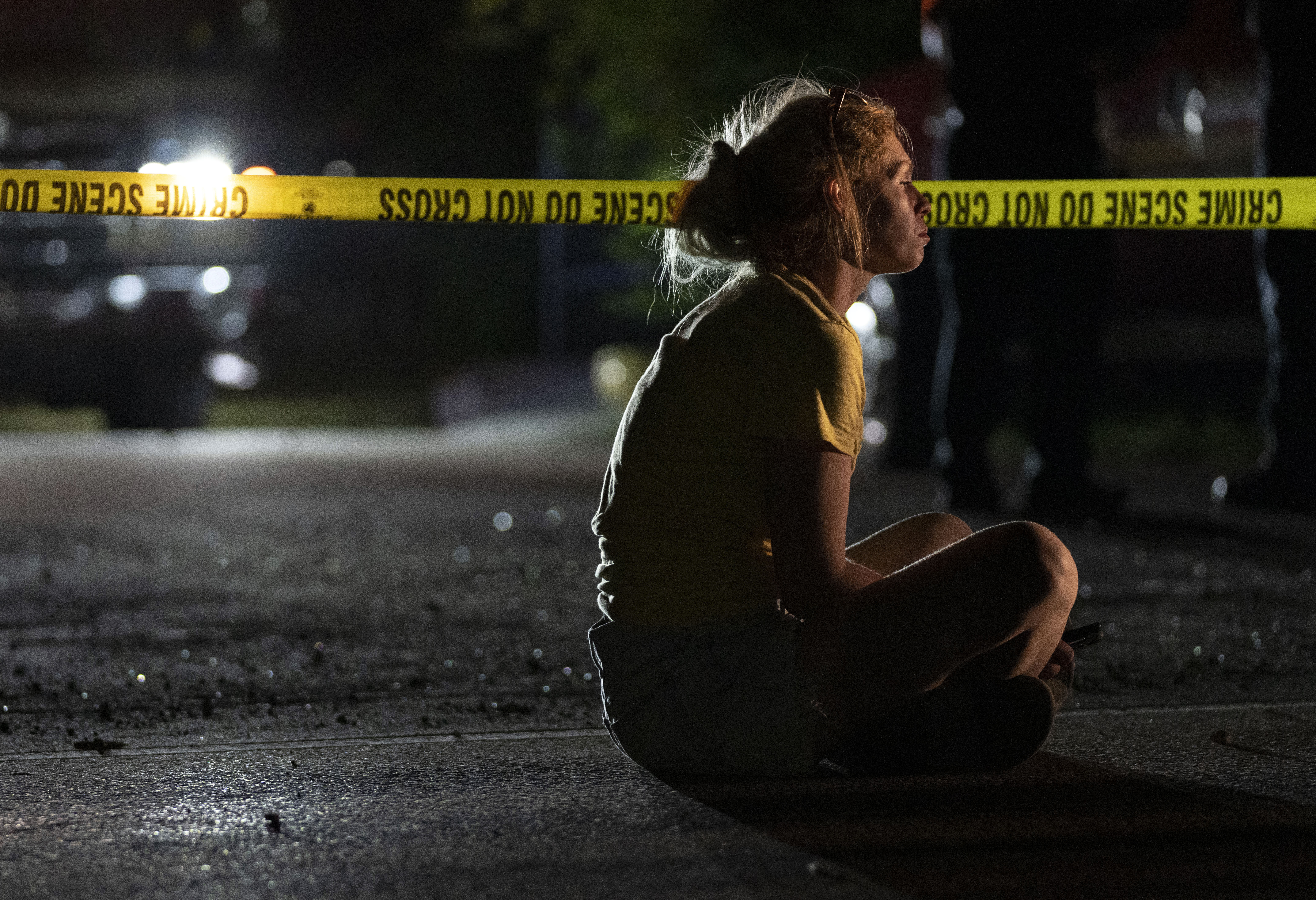 A woman watches the search, which ended when the bodies of a man and his three young children were found in a submerged car