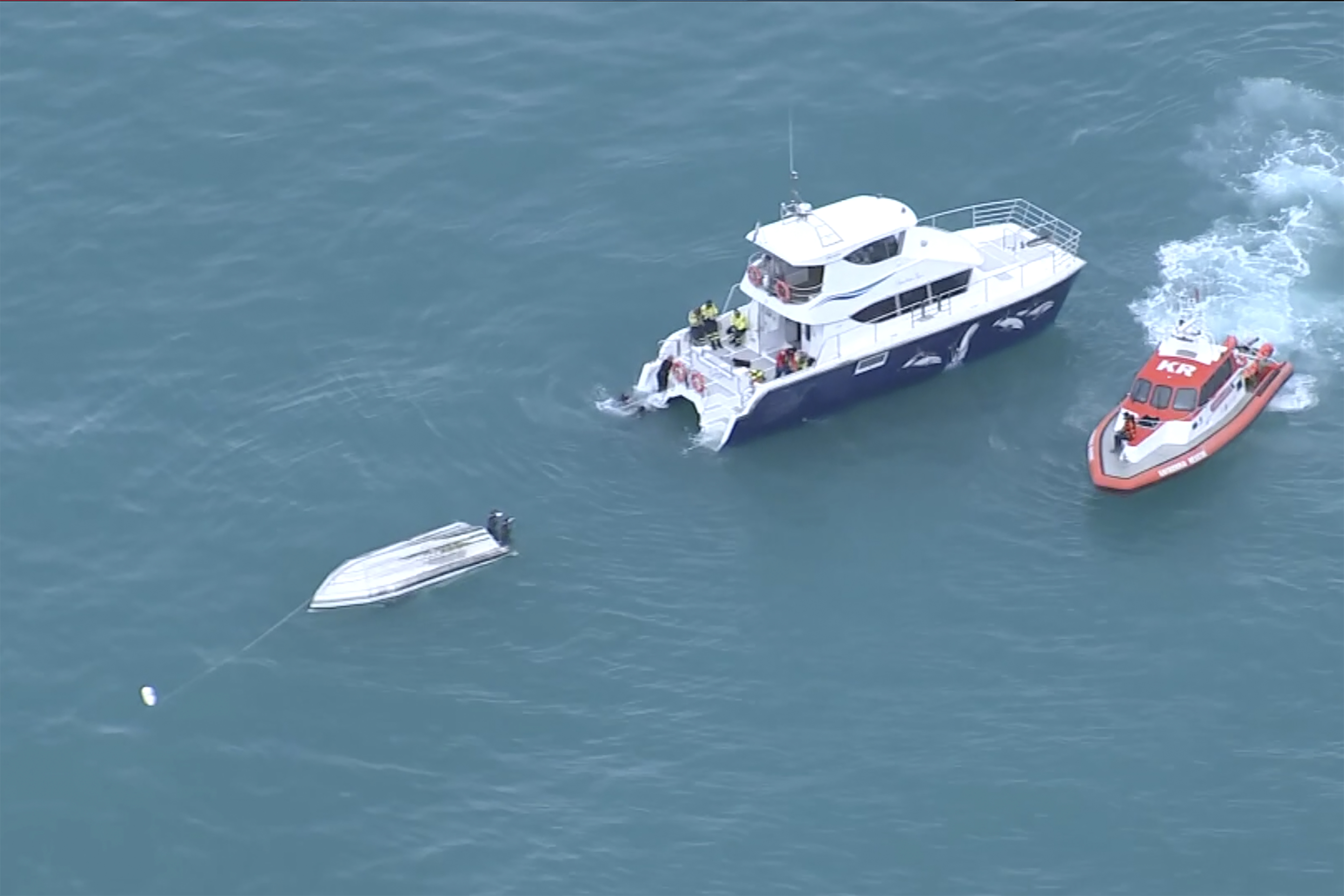 Two rescue boats alongside a capsized boat in Kaikoura, New Zealand