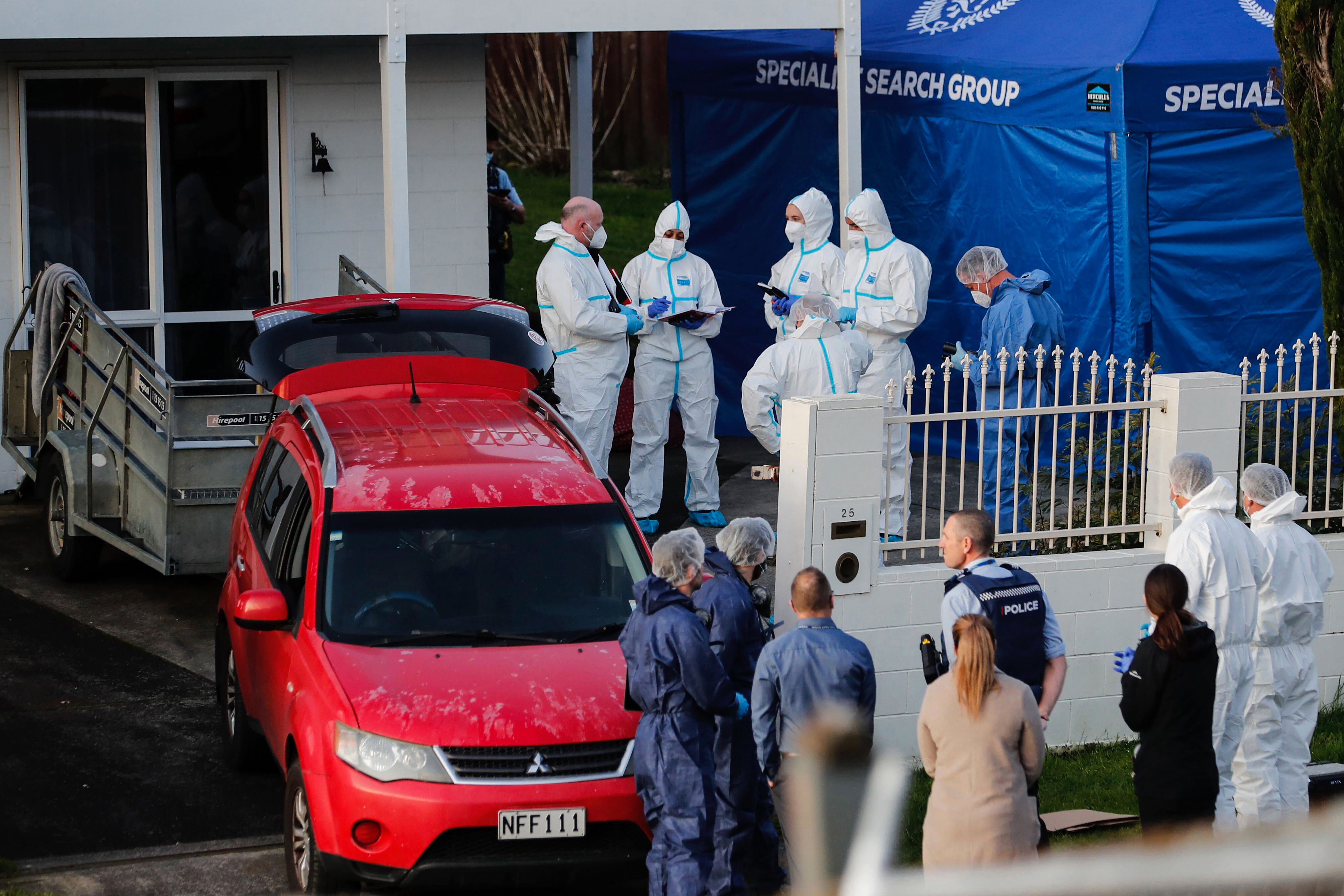New Zealand police investigators work at a scene in Auckland on Aug. 11, 2022, after bodies were discovered in suitcases