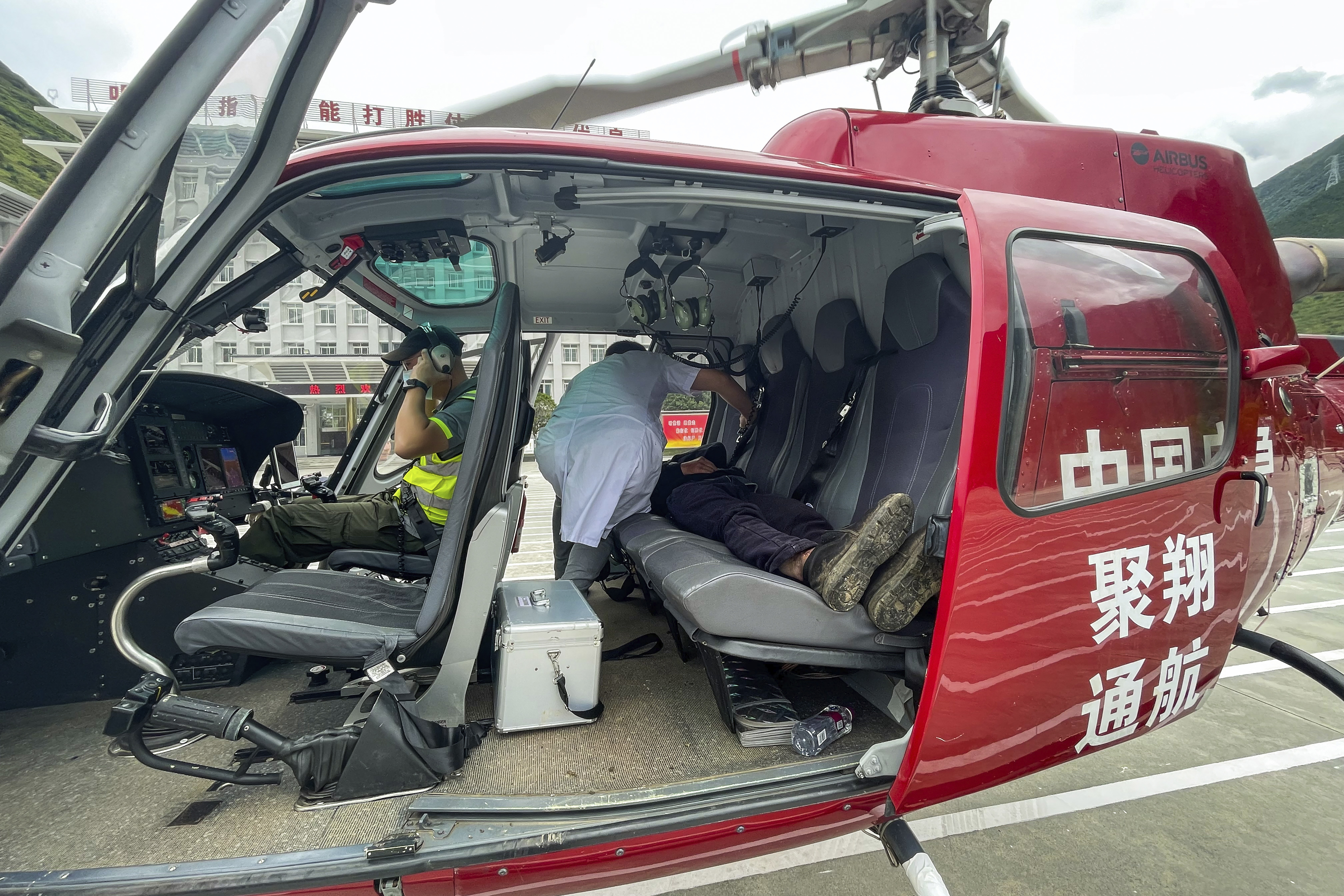 Gan Yu, a hydropower station worker who had gone missing for 17 days after an earthquake, lies on the backseat of a helicopter after being found and evacuated to Luding County