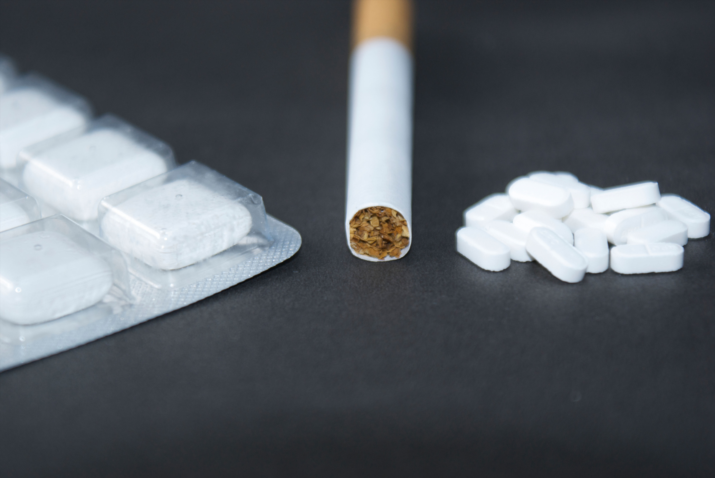 A cigarette, nicotine gum and anti-smoking pills