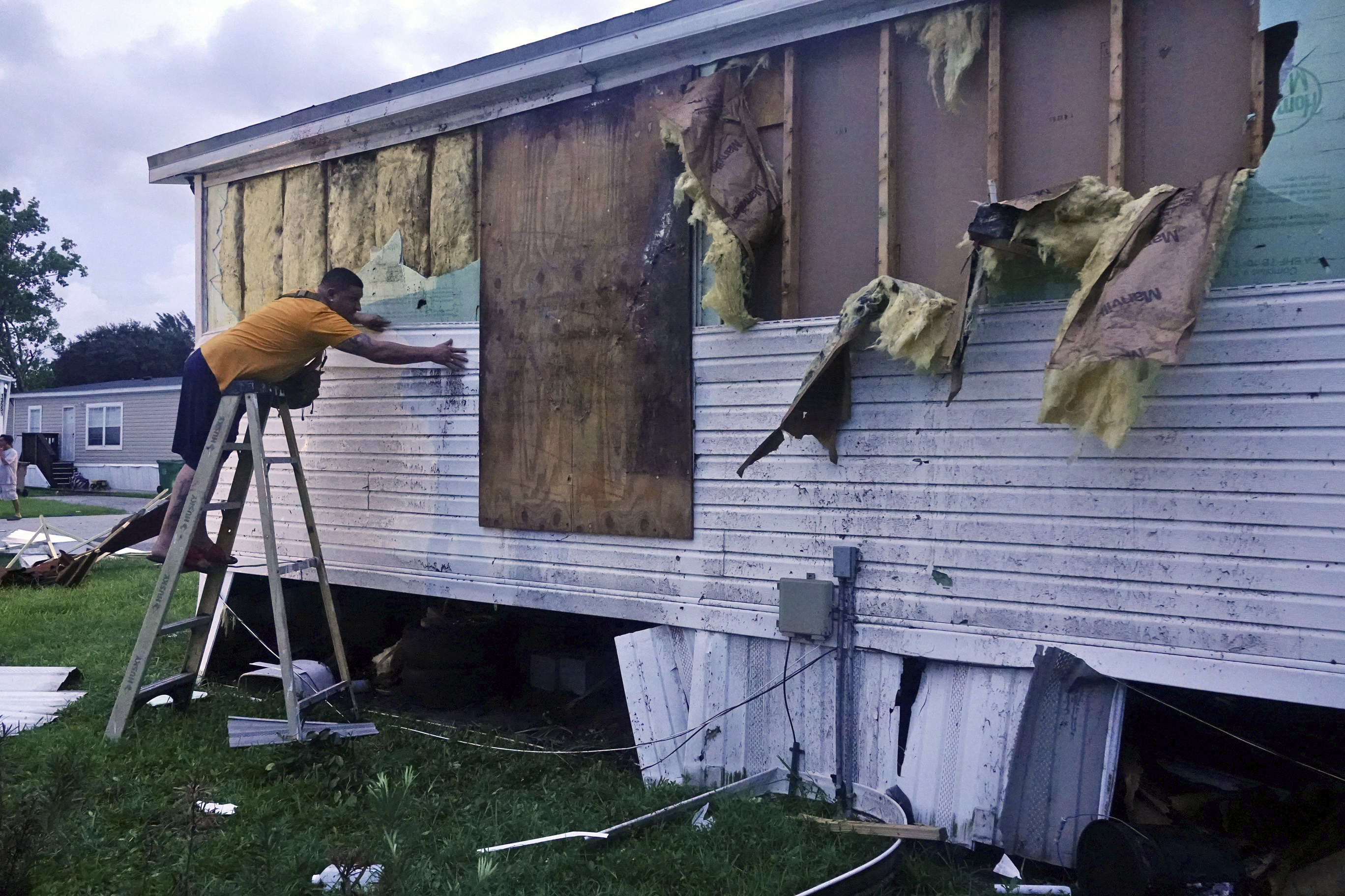Ivan Mendoza begins to repair damage at his mobile home in Davie, Florida
