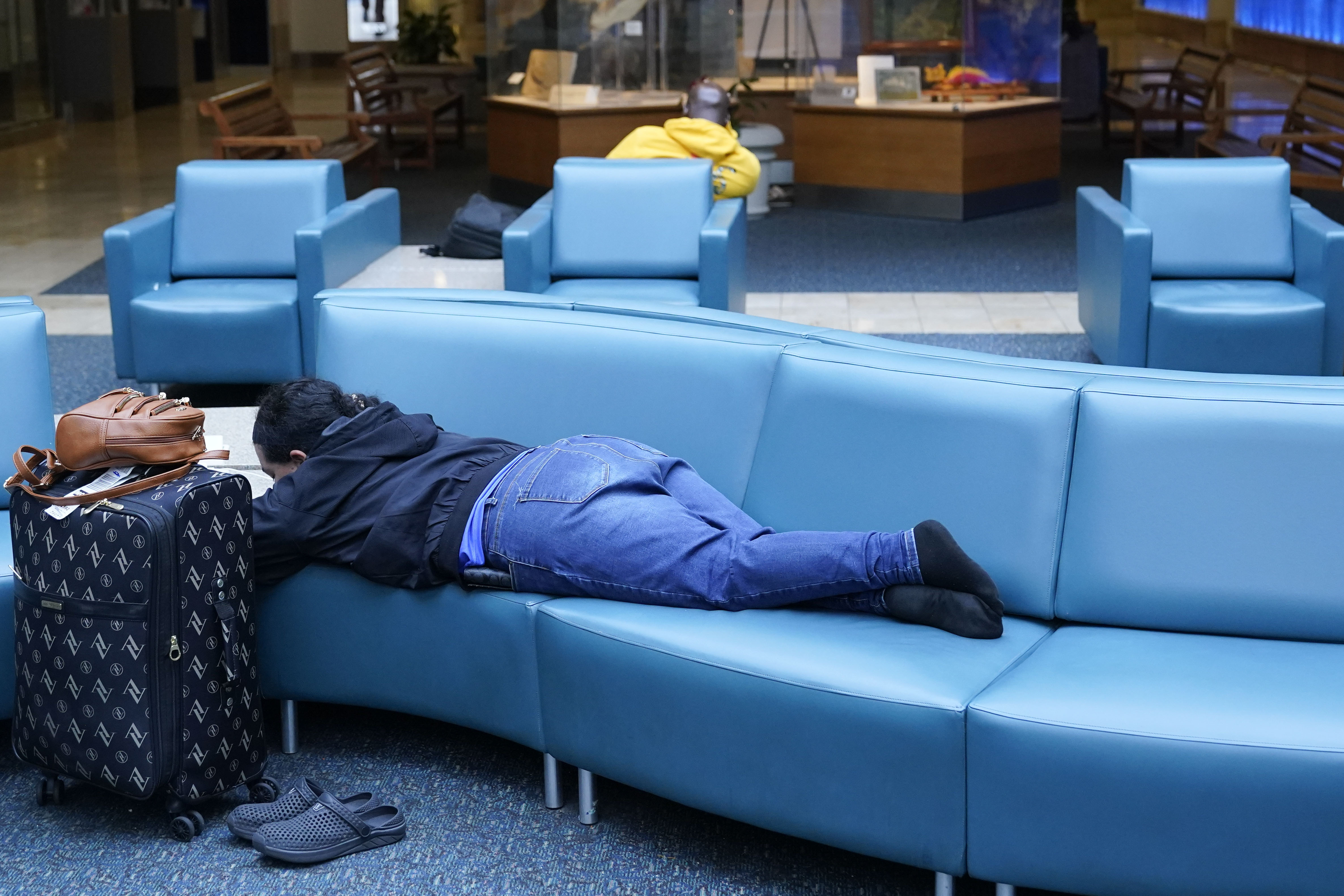 A traveller rests on a couch at the Orlando Airport prior to the facility being closed ahead of Hurricane Ian