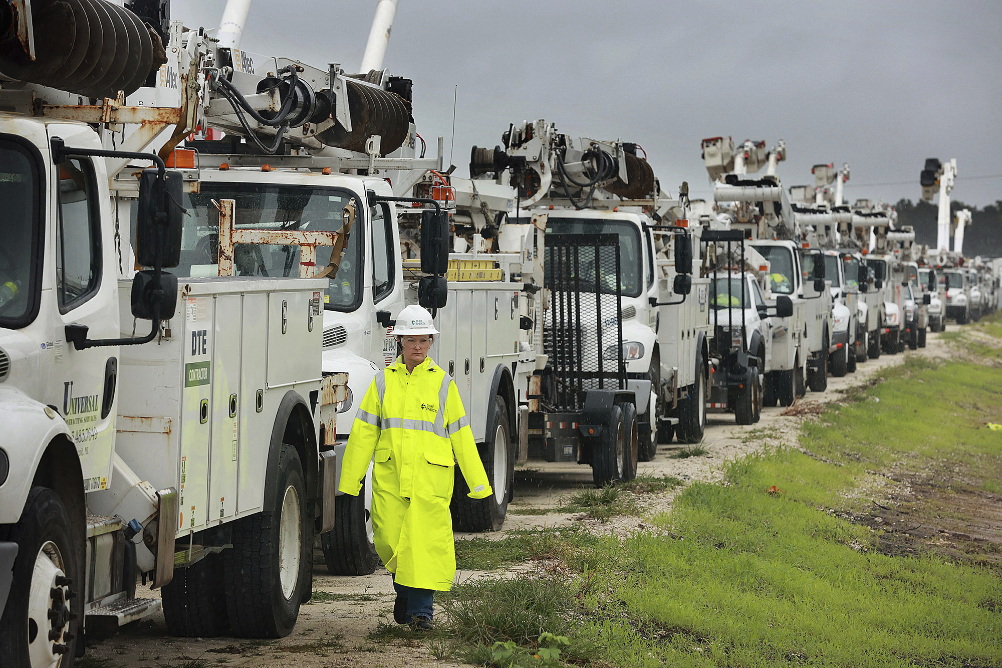 Heather Danenhower from Duke Energy walks around utility trucks in The Villages of Sumter County, Florida