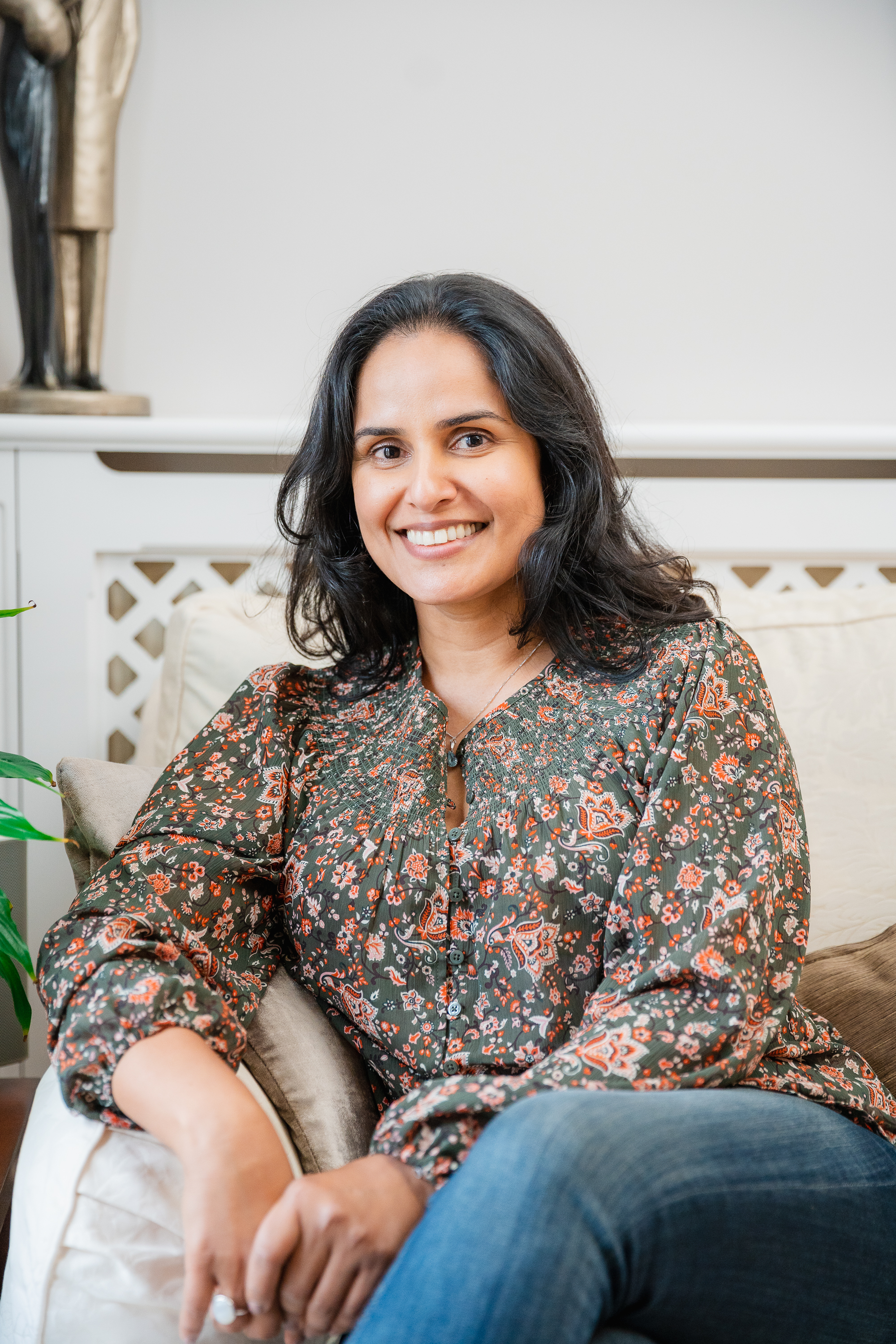 Navinder sitting on a sofa at her home in Surbiton, south west London