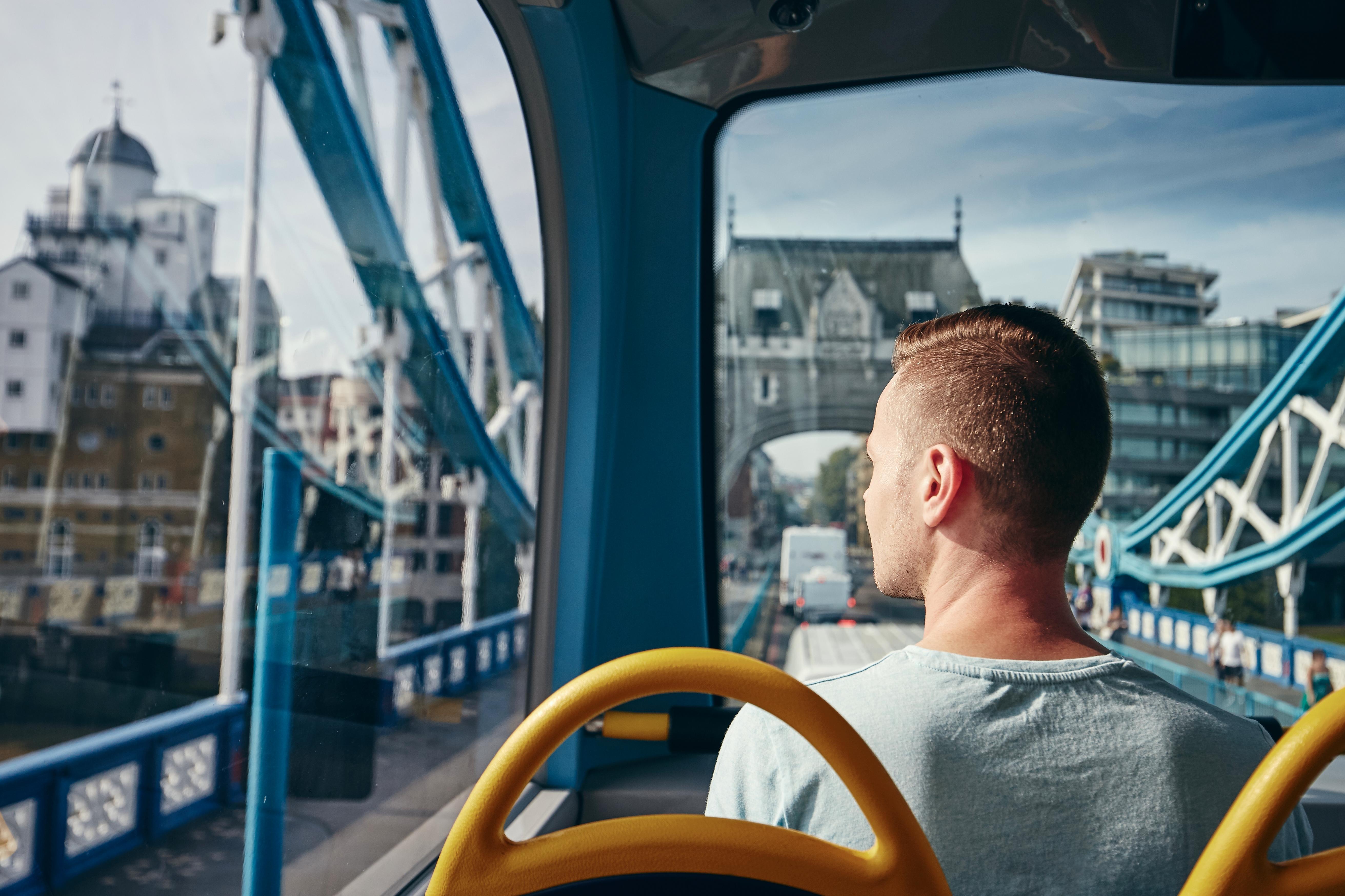 Young man looking through window from double decker bus in London