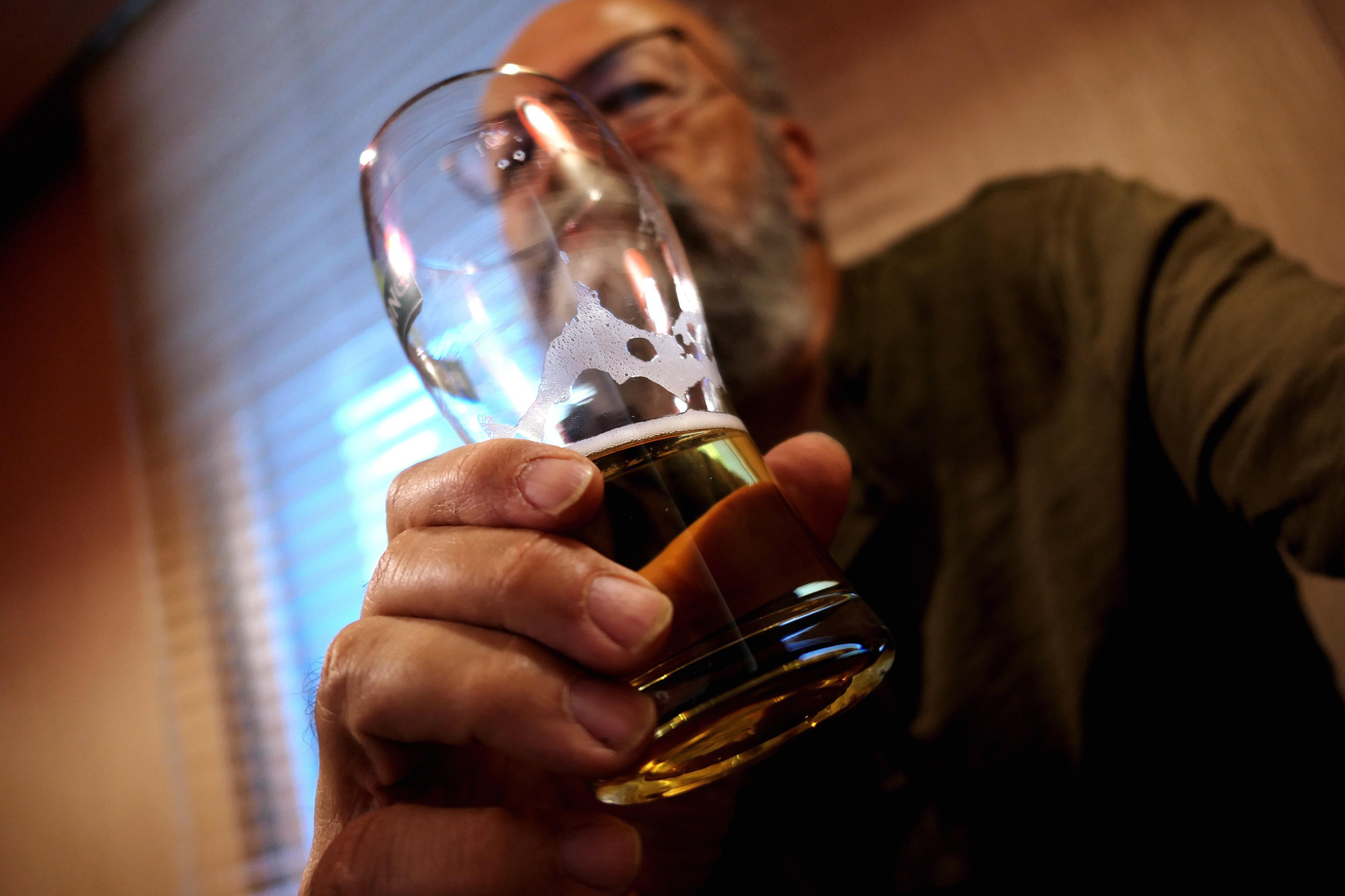 man holding glass of beer