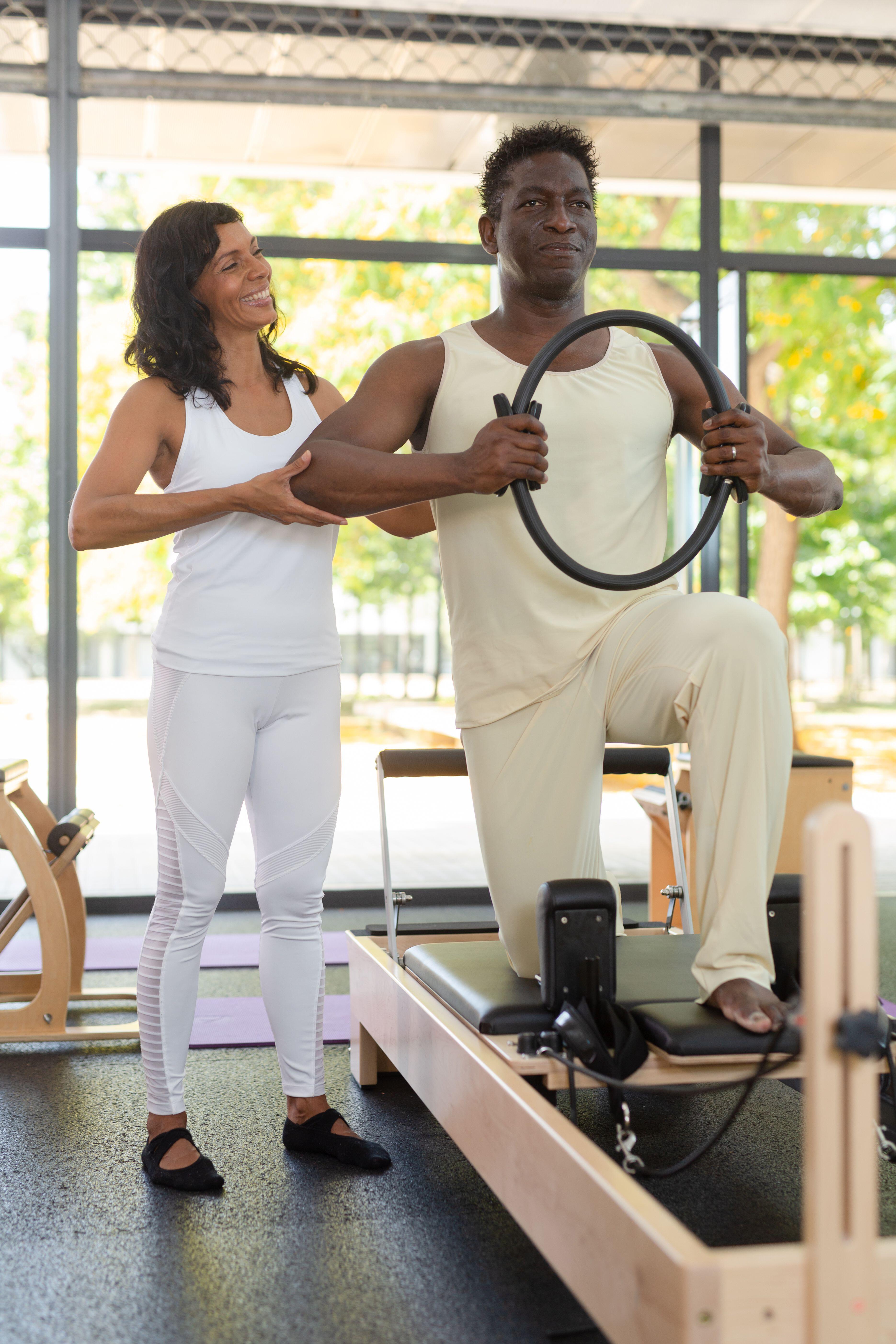 Man getting coached in reformer Pilates