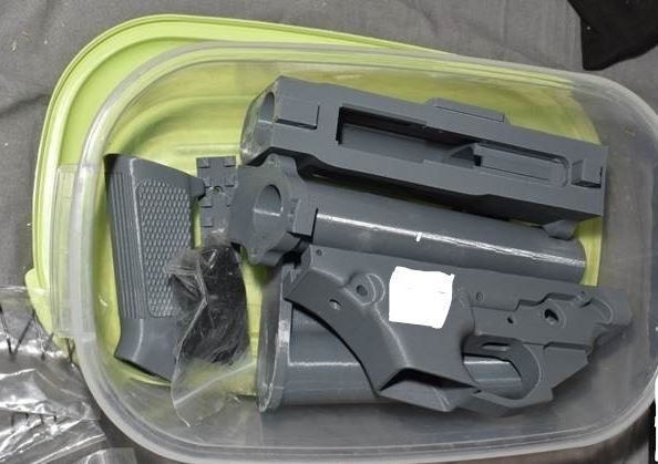 Grey gun components in a plastic box
