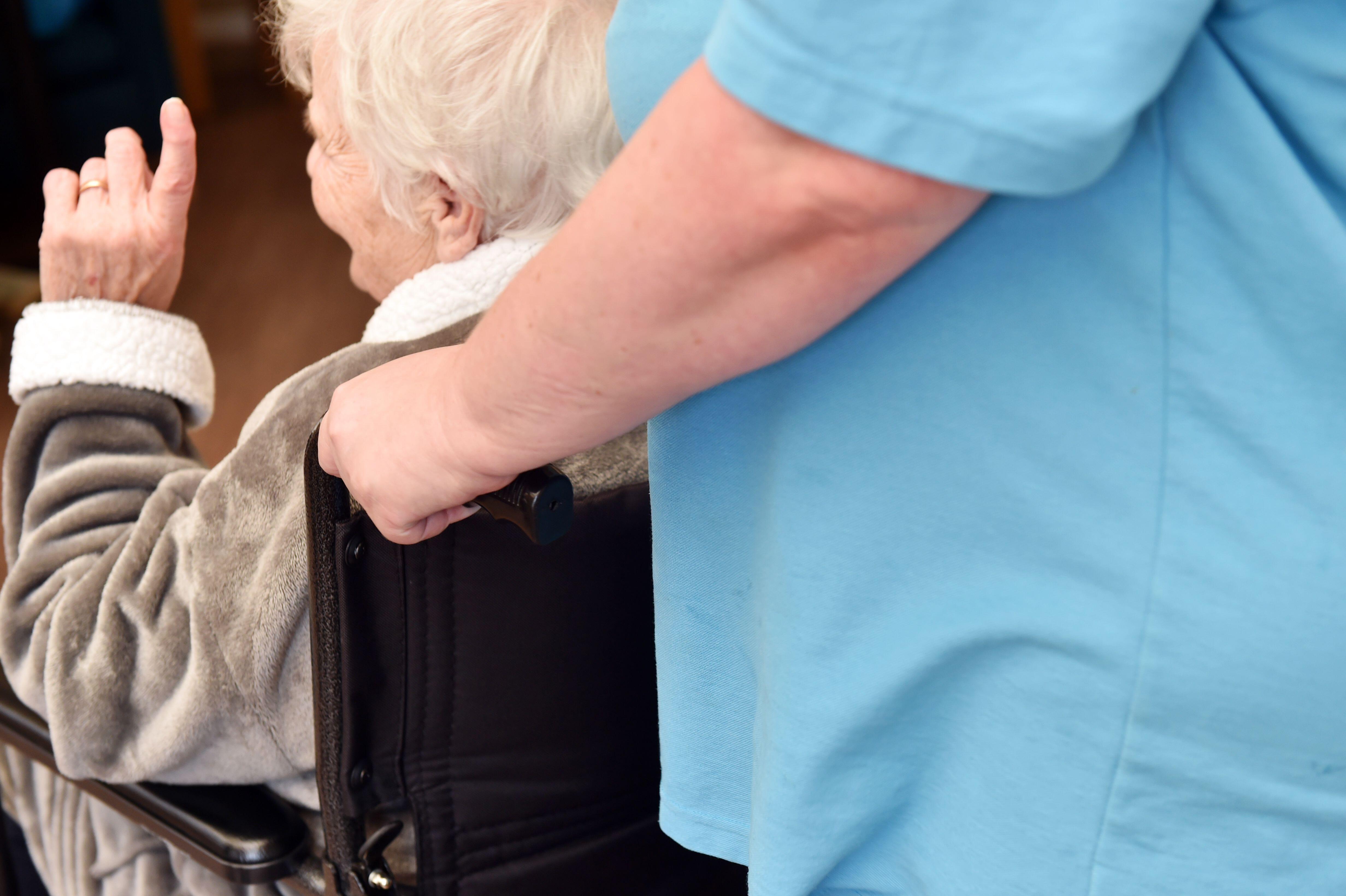 Care home staff help elderly people move about the care home, Yorkshire UK