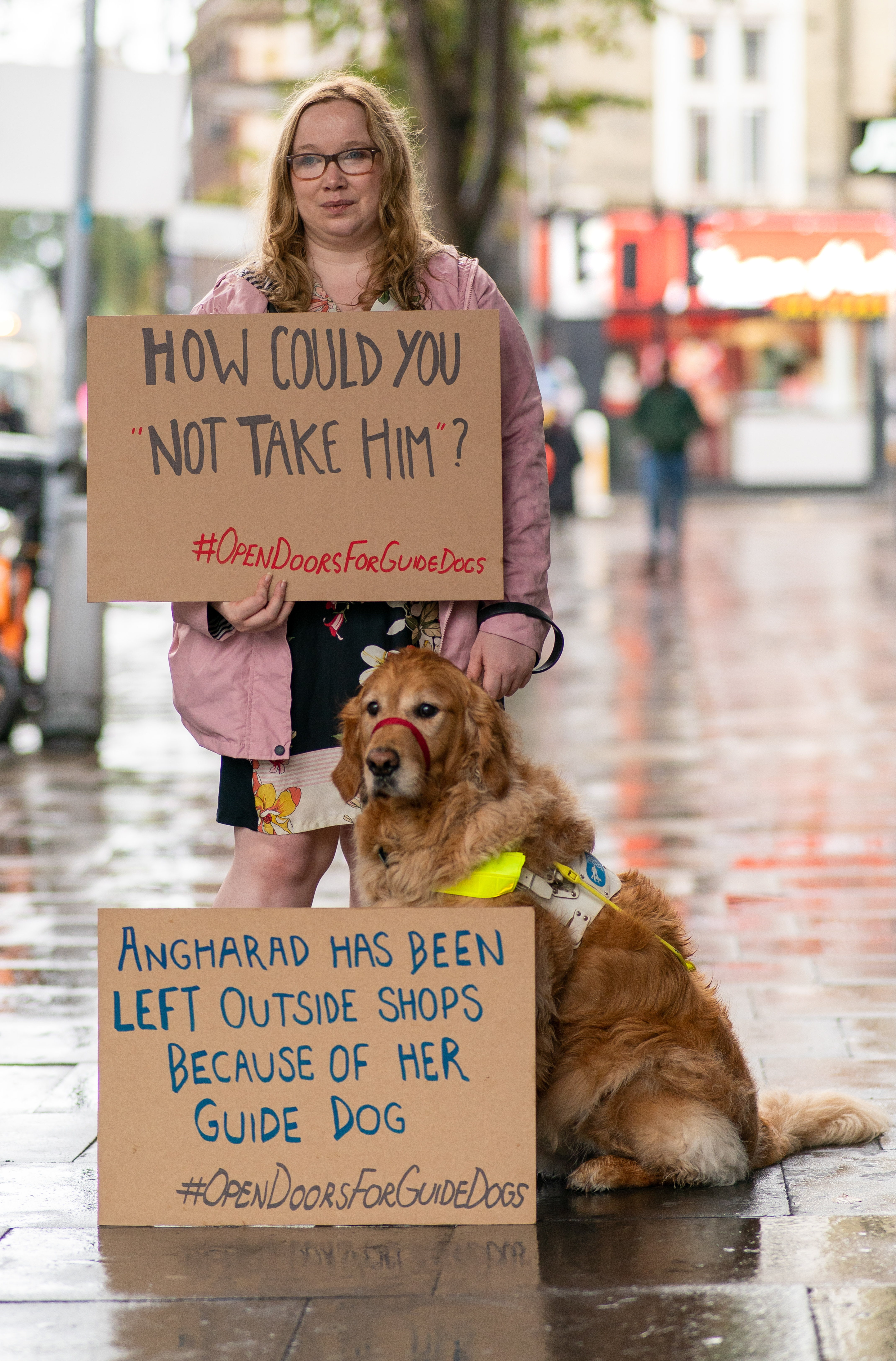Woman posing with her dog and carboard placards