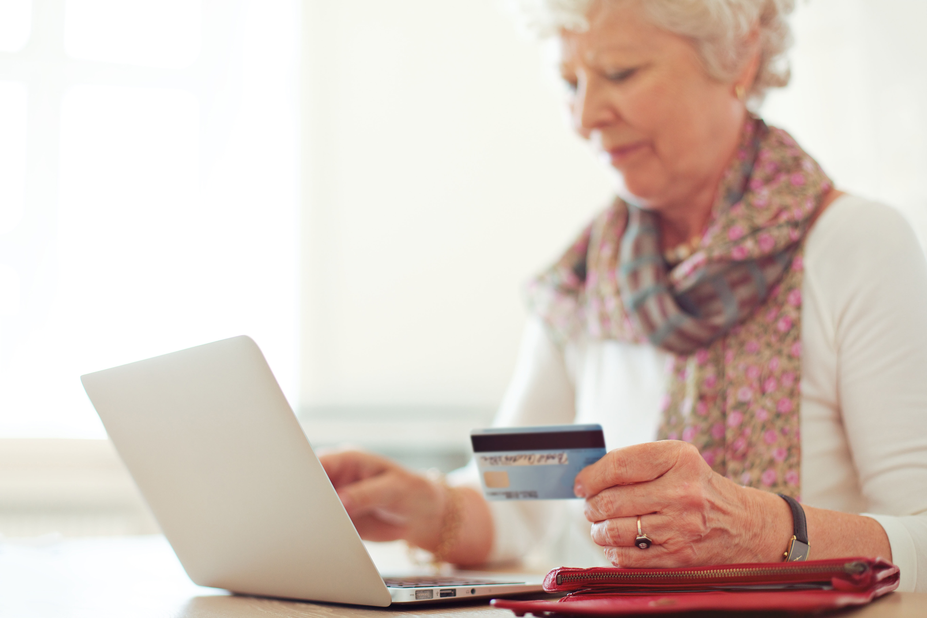 A grandmother doing online banking at home on a laptop