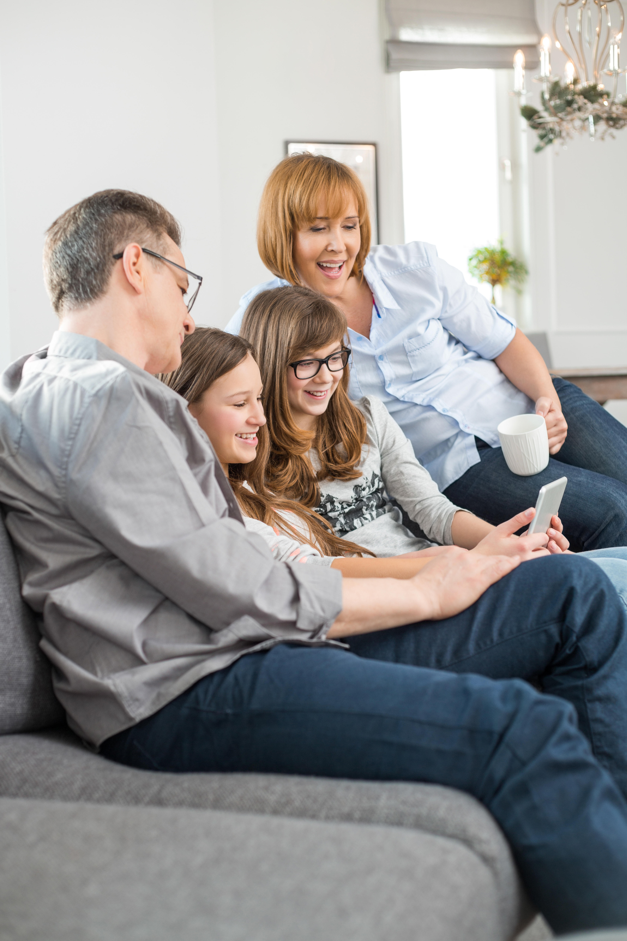 family using tablet PC on sofa at home
