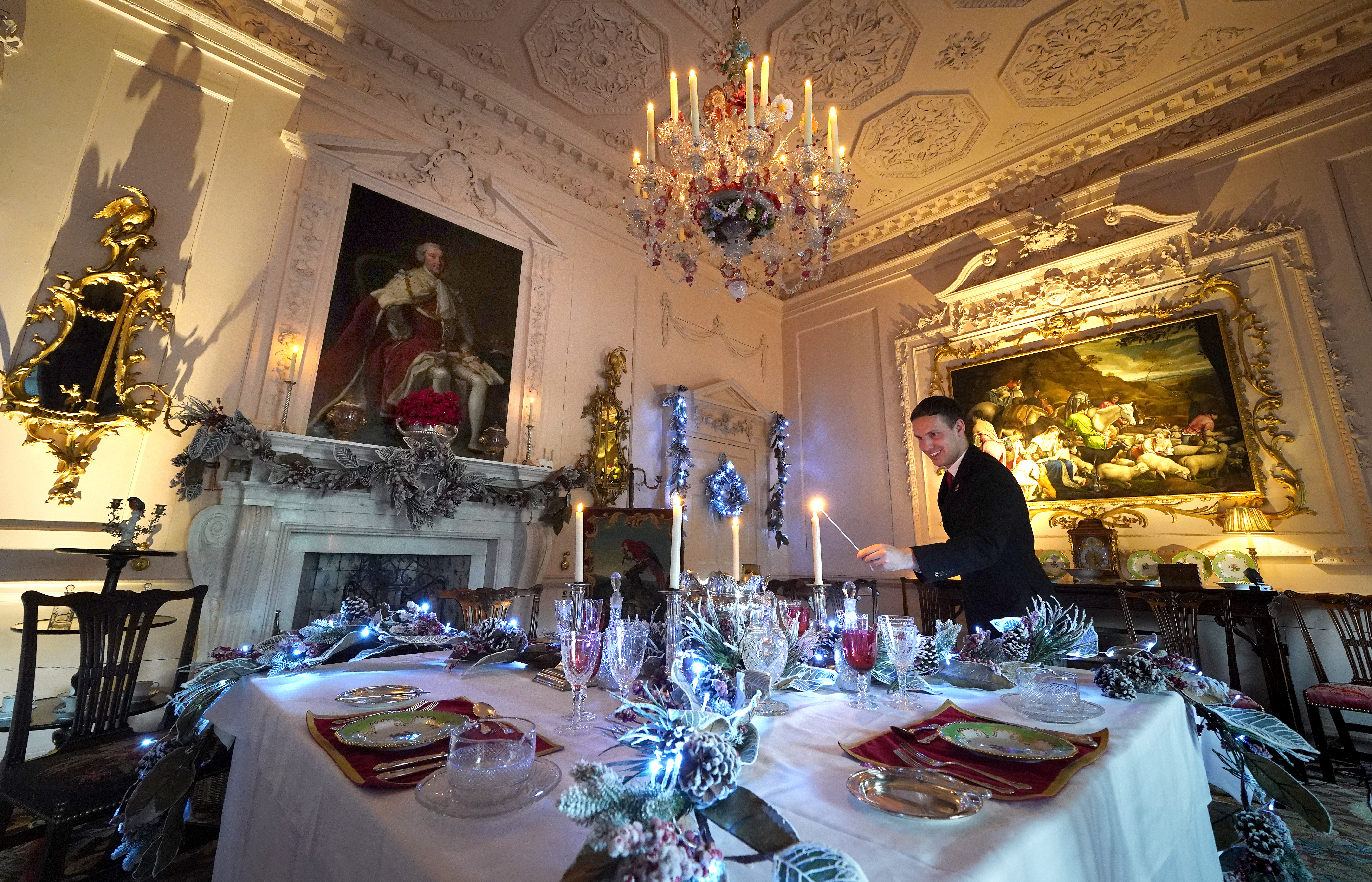 House Butler Michael Russell lights a candle in The Pink Dining Room at Dumfries House, in Cumnock, Scotland