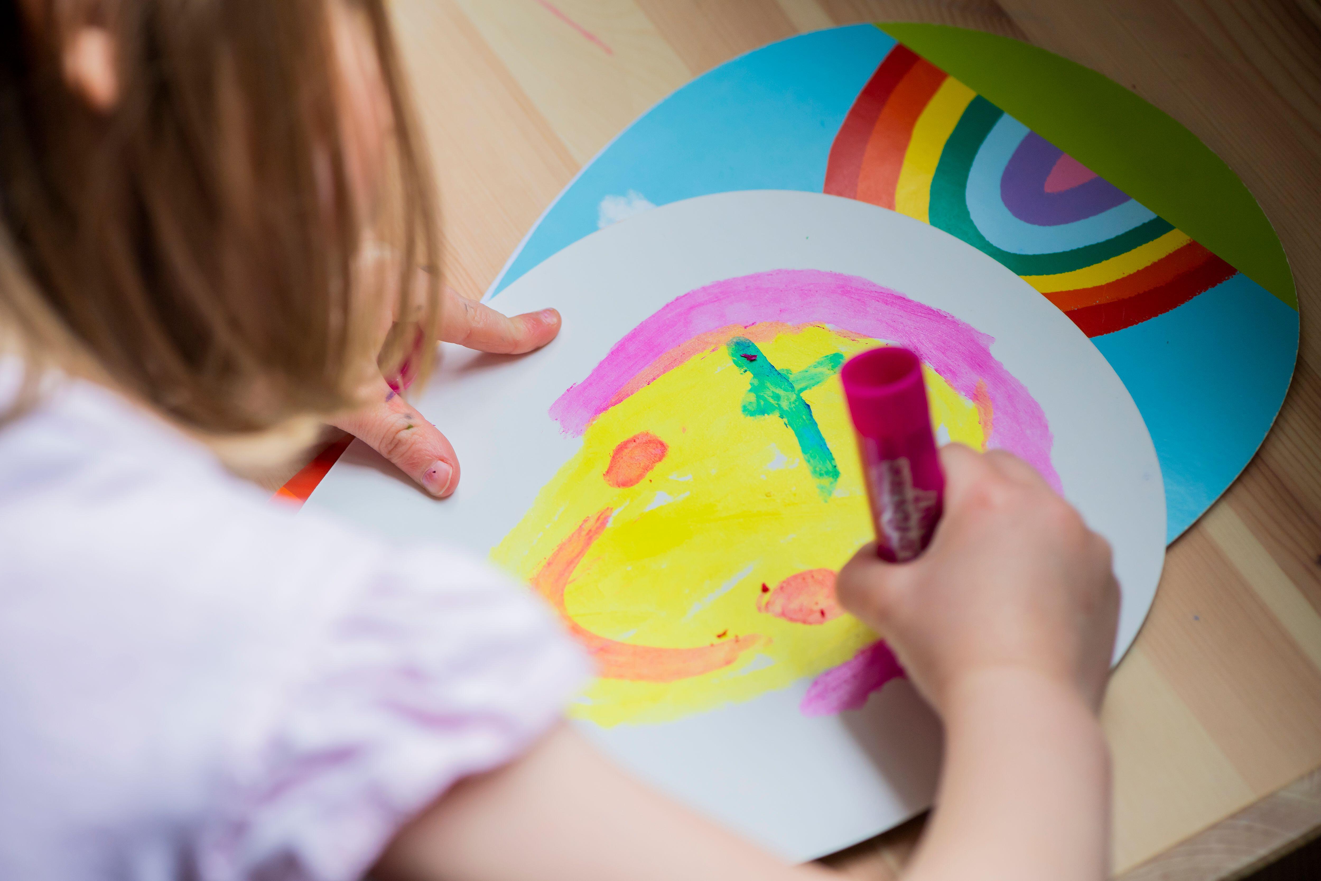 A young girl paints a smiley face
