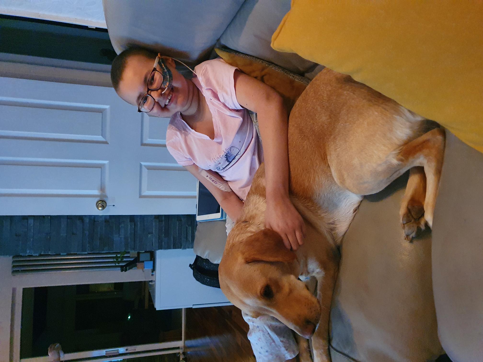 Alyssa is recovering at home and is pictured here with their family dog, Holly (Family handout/PA)