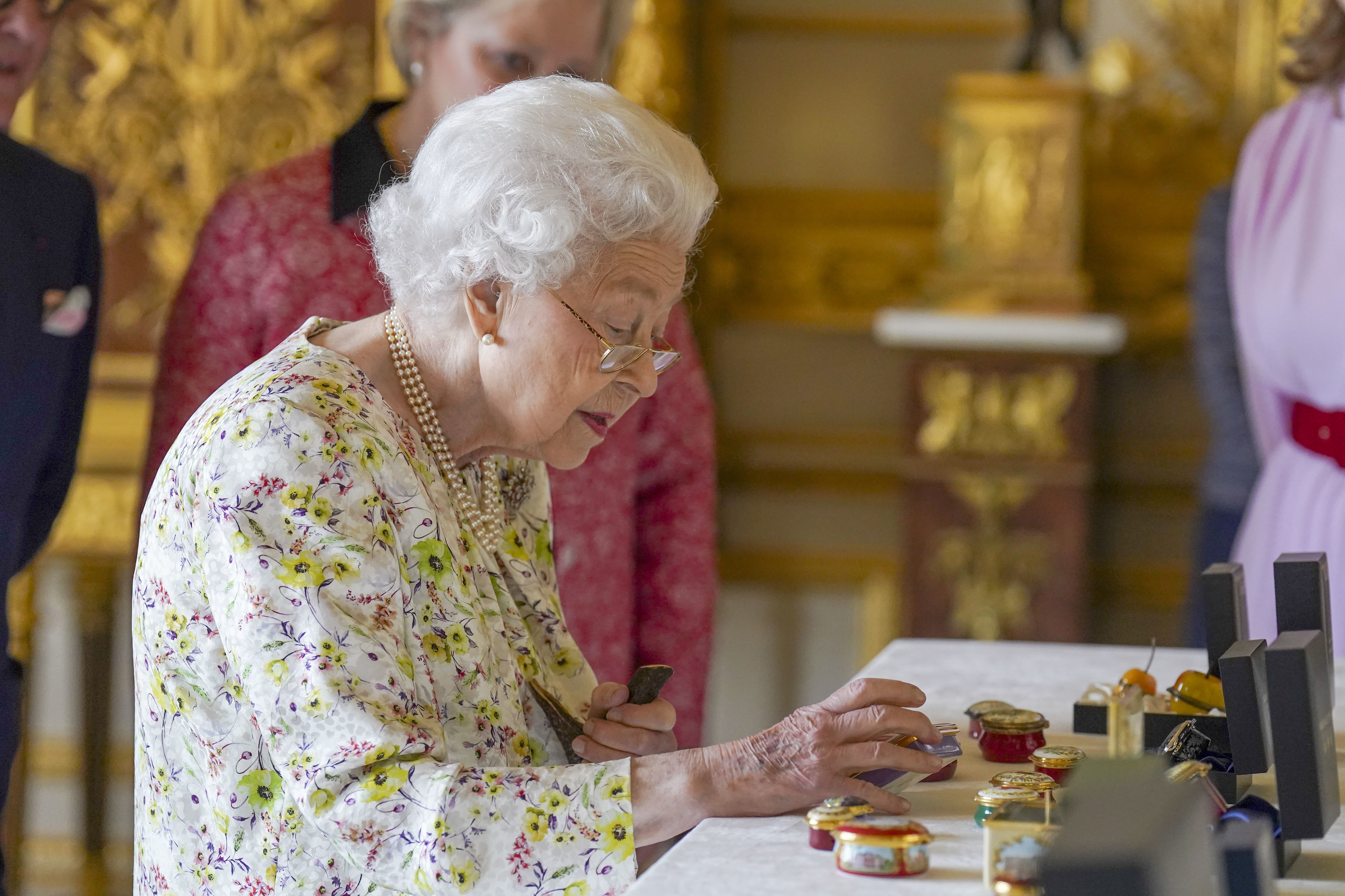 The Queen examines artefacts