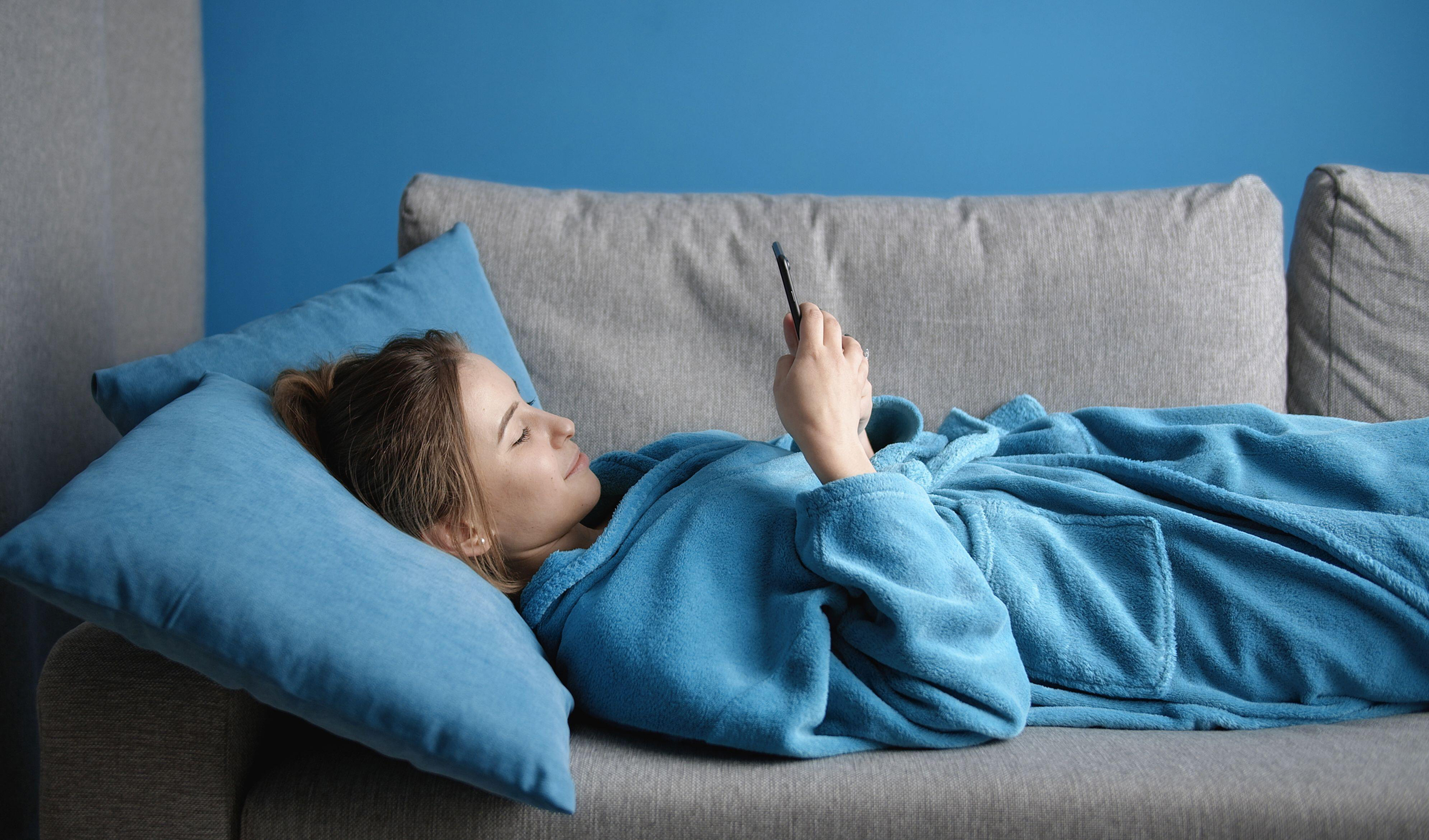 Woman lying on sofa in dressing gown