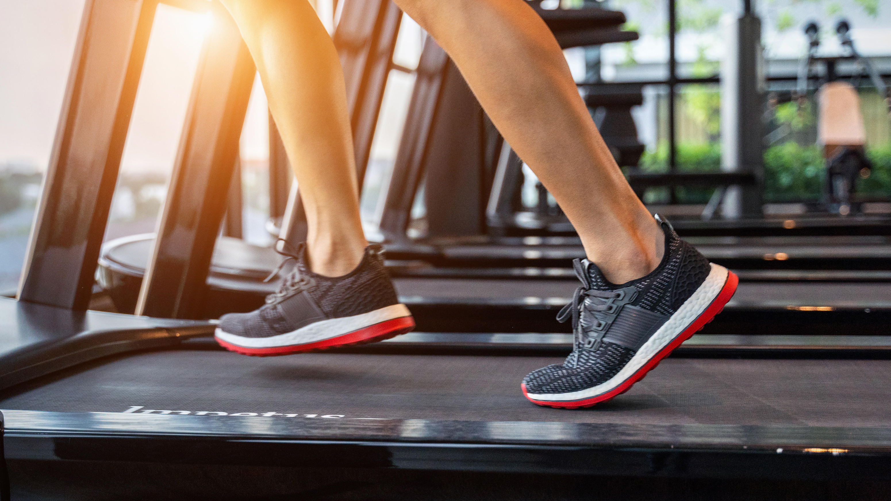 feet in sneakers running on the treadmill at the gym