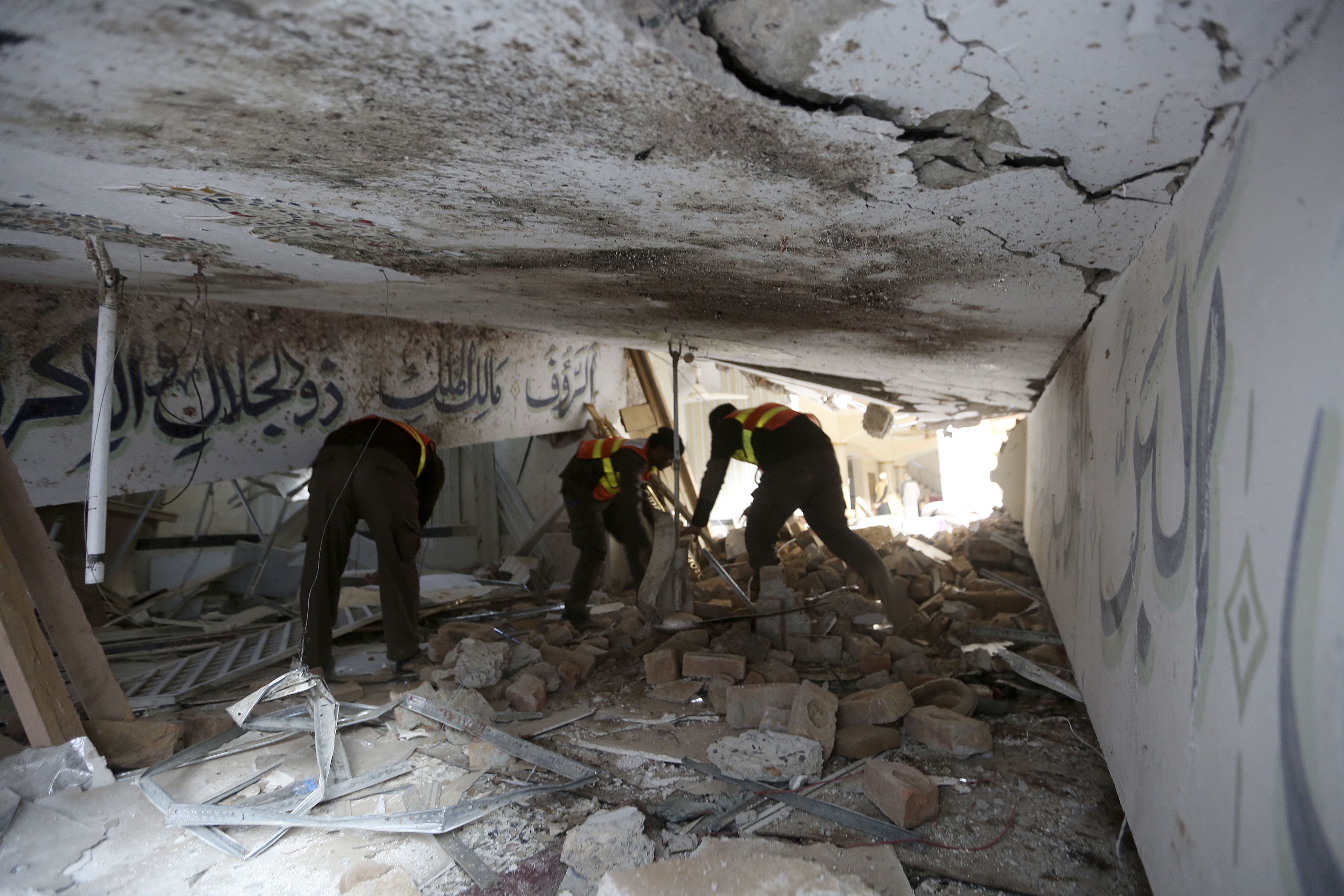 Rescue workers examine a damage portion of the mosque