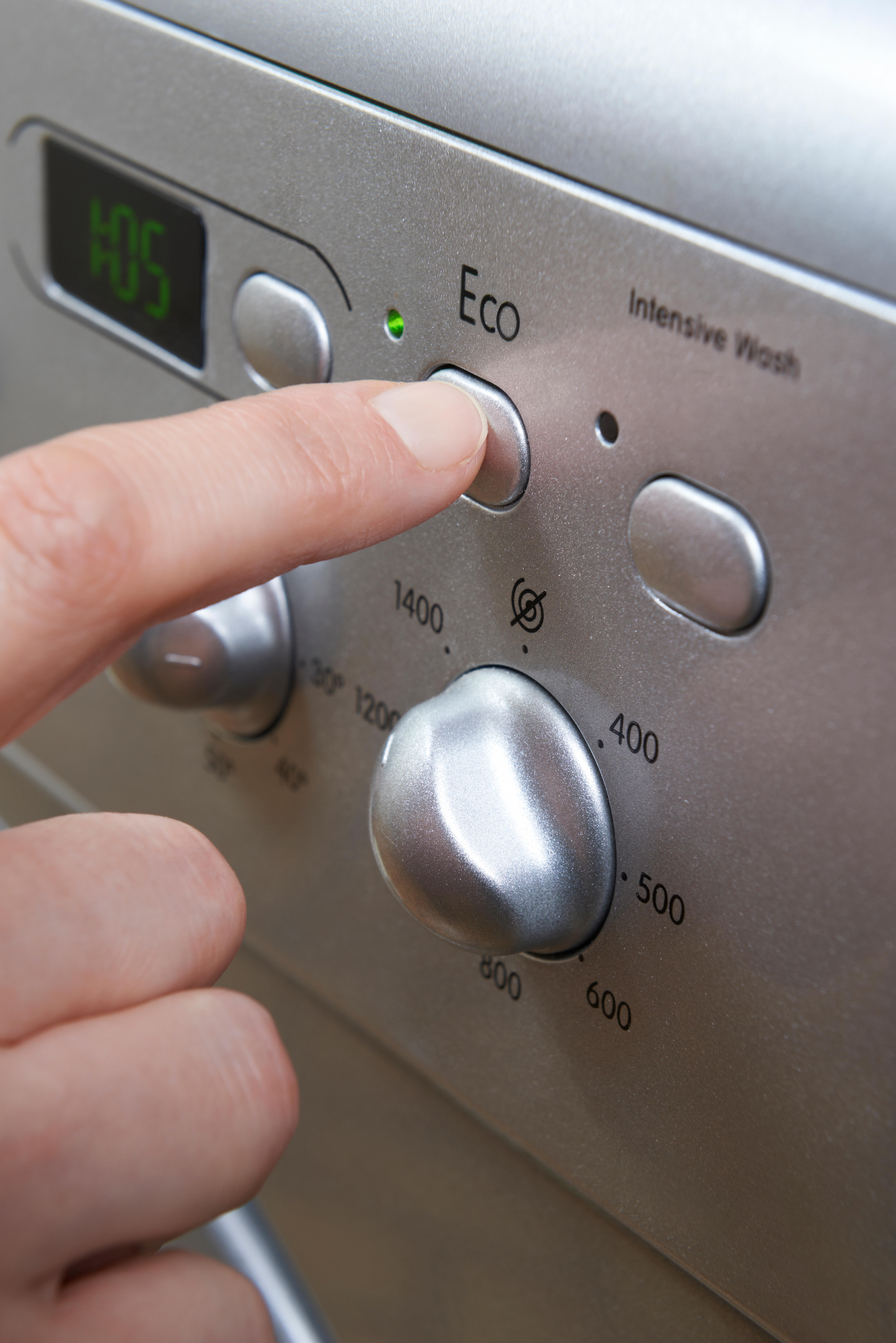 woman choosing eco on washing machine