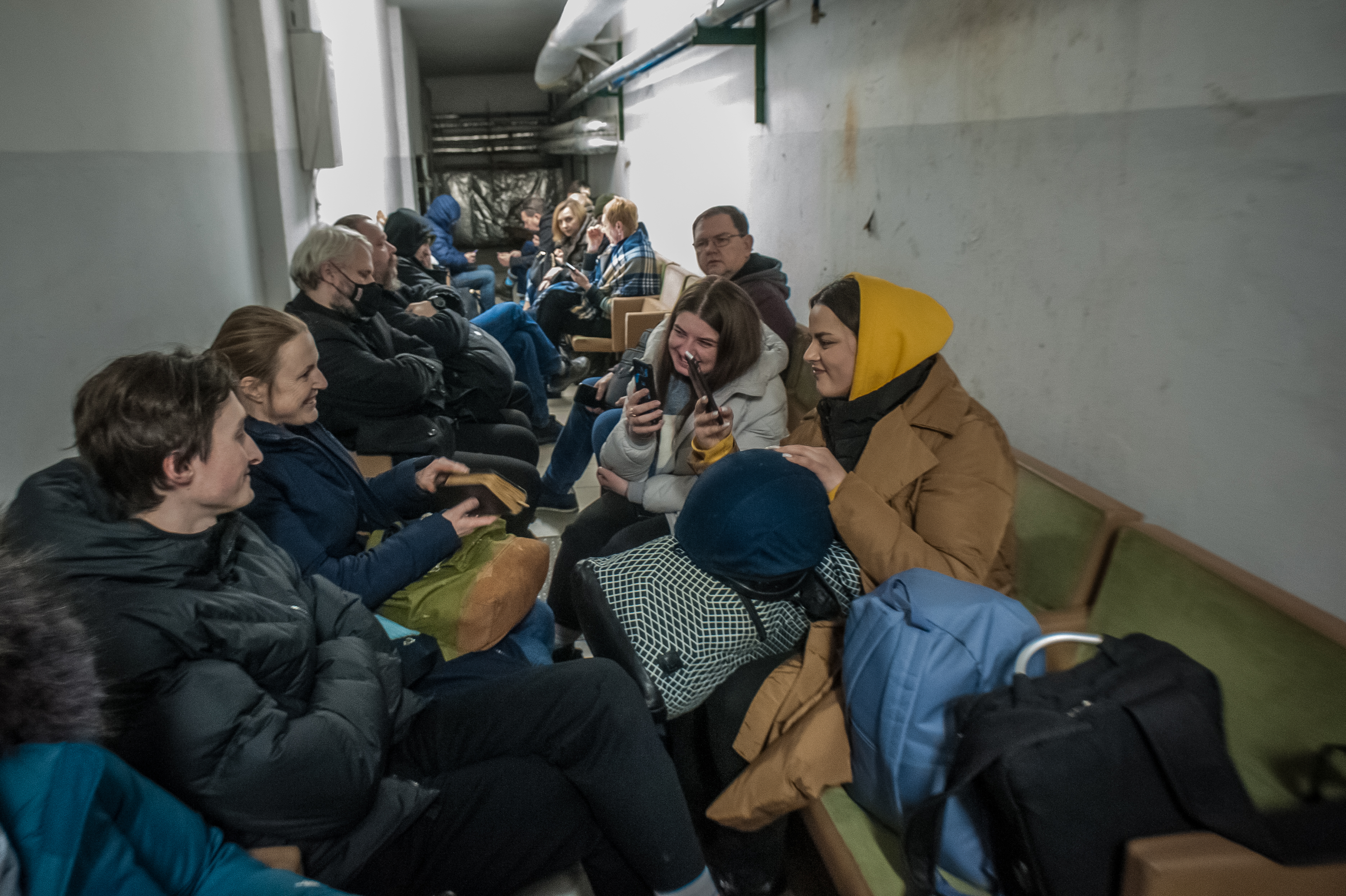 People sitting, smiling and using phones in a room